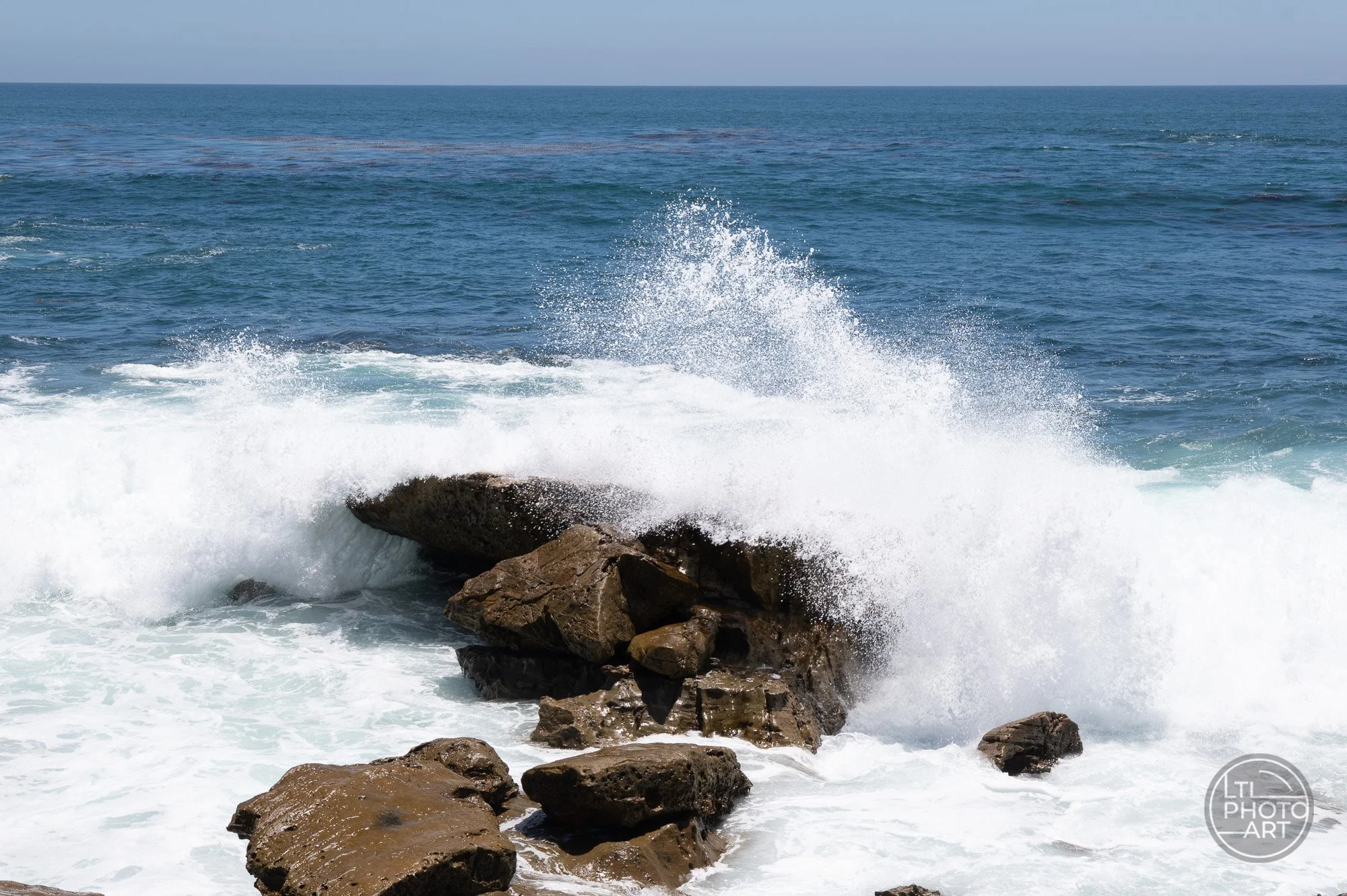 Wave crashing over rocks at Monument Point in Laguna Beach, photographed at 1/350 second and ISO 280 to show the impact of timing in coastal photography.
