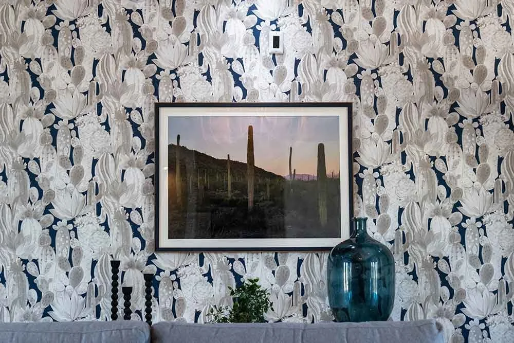 Large framed landscape photograph displayed above a sofa, illustrating how a single statement piece of fine art photography creates a dramatic focal point in a living space.
