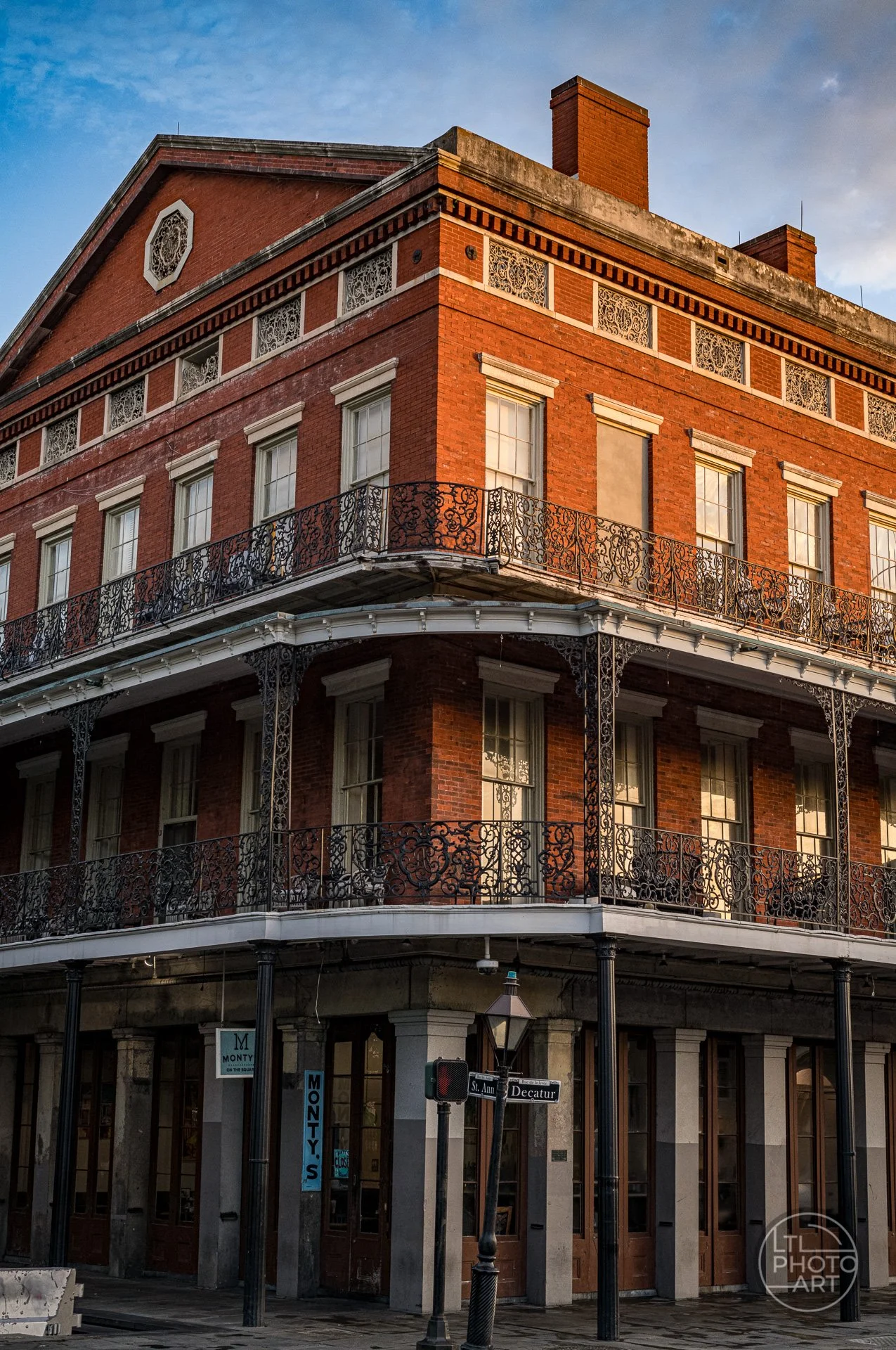 Historic Pontalba Buildings in New Orleans with warm morning light illuminating the red-brick facade and wrought-iron balconies.