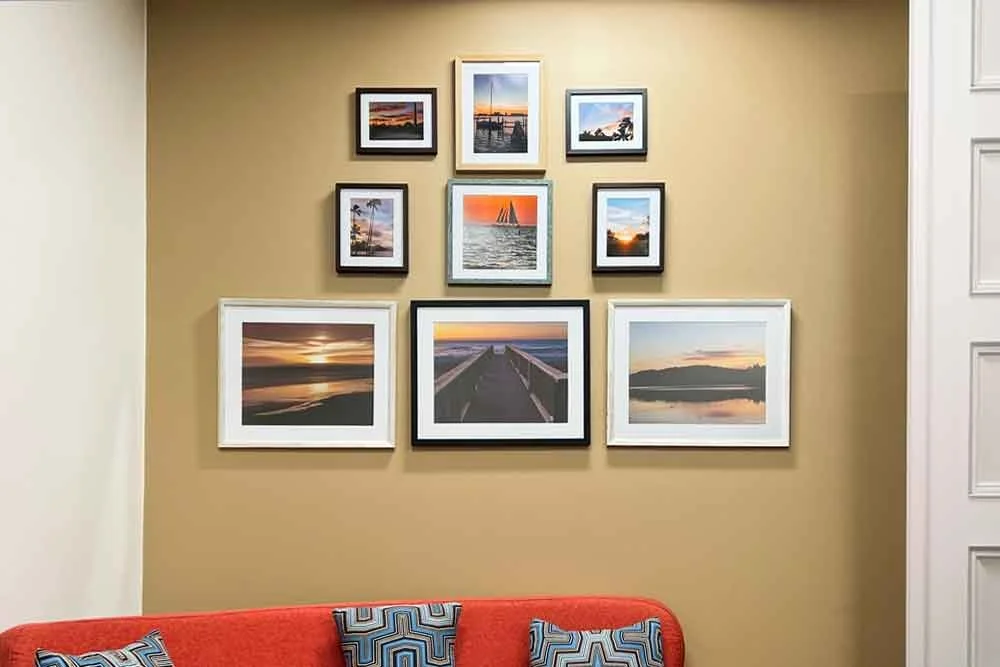 Symmetrical gallery wall featuring coordinated framed coastal photographs arranged above a sofa, illustrating a balanced and elegant wall art design.