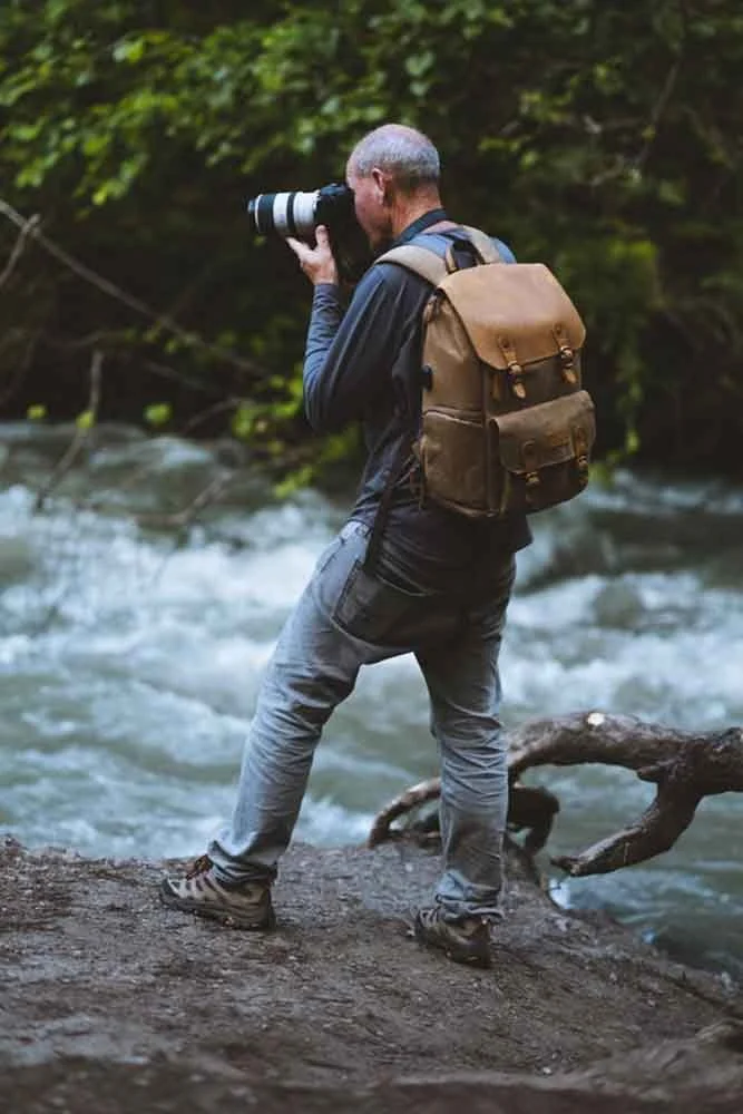 Lyle Lansdell photographing along a mountain river in Alaska during a landscape photography assignment.
