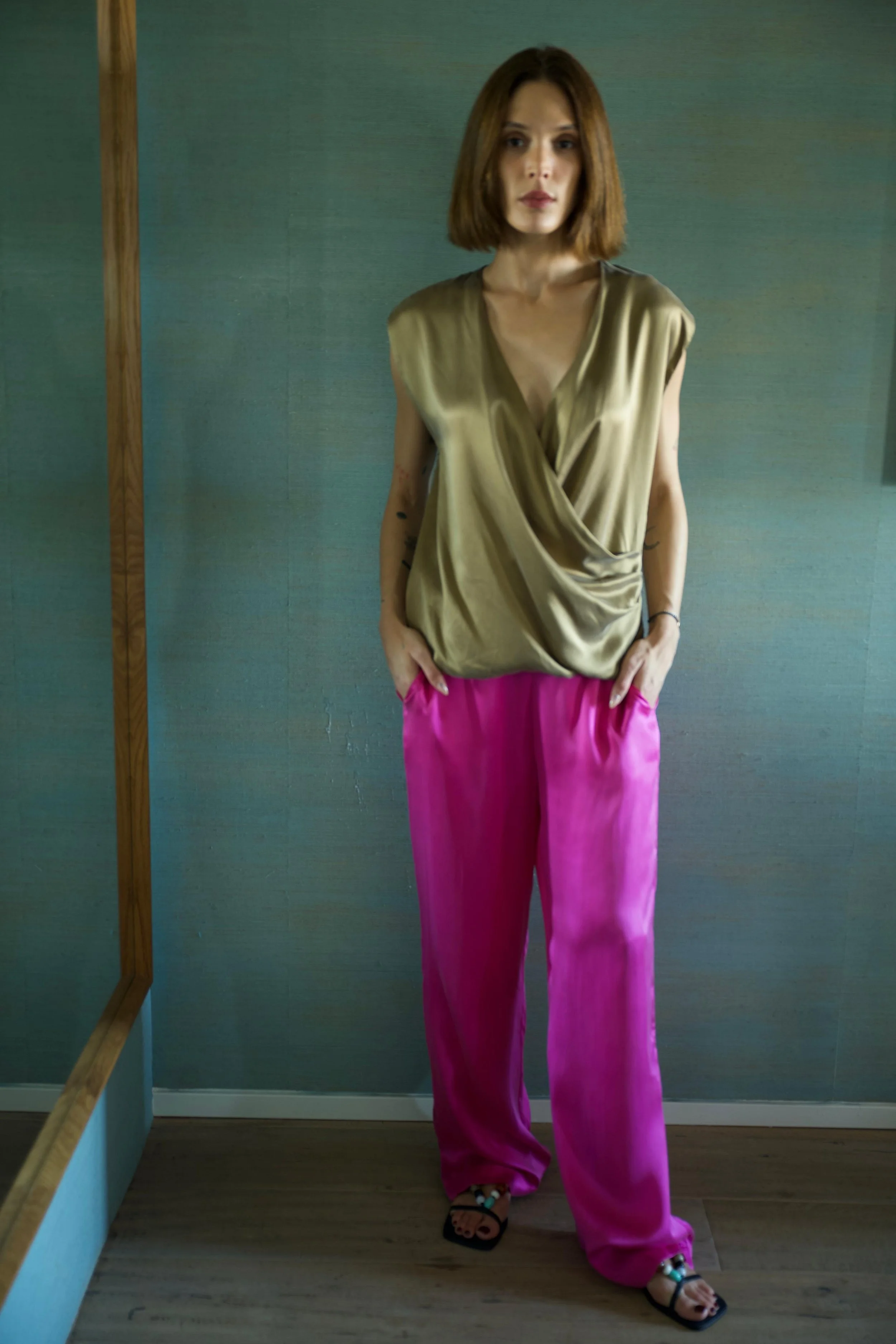 Woman seated wearing grey silk loungewear pants