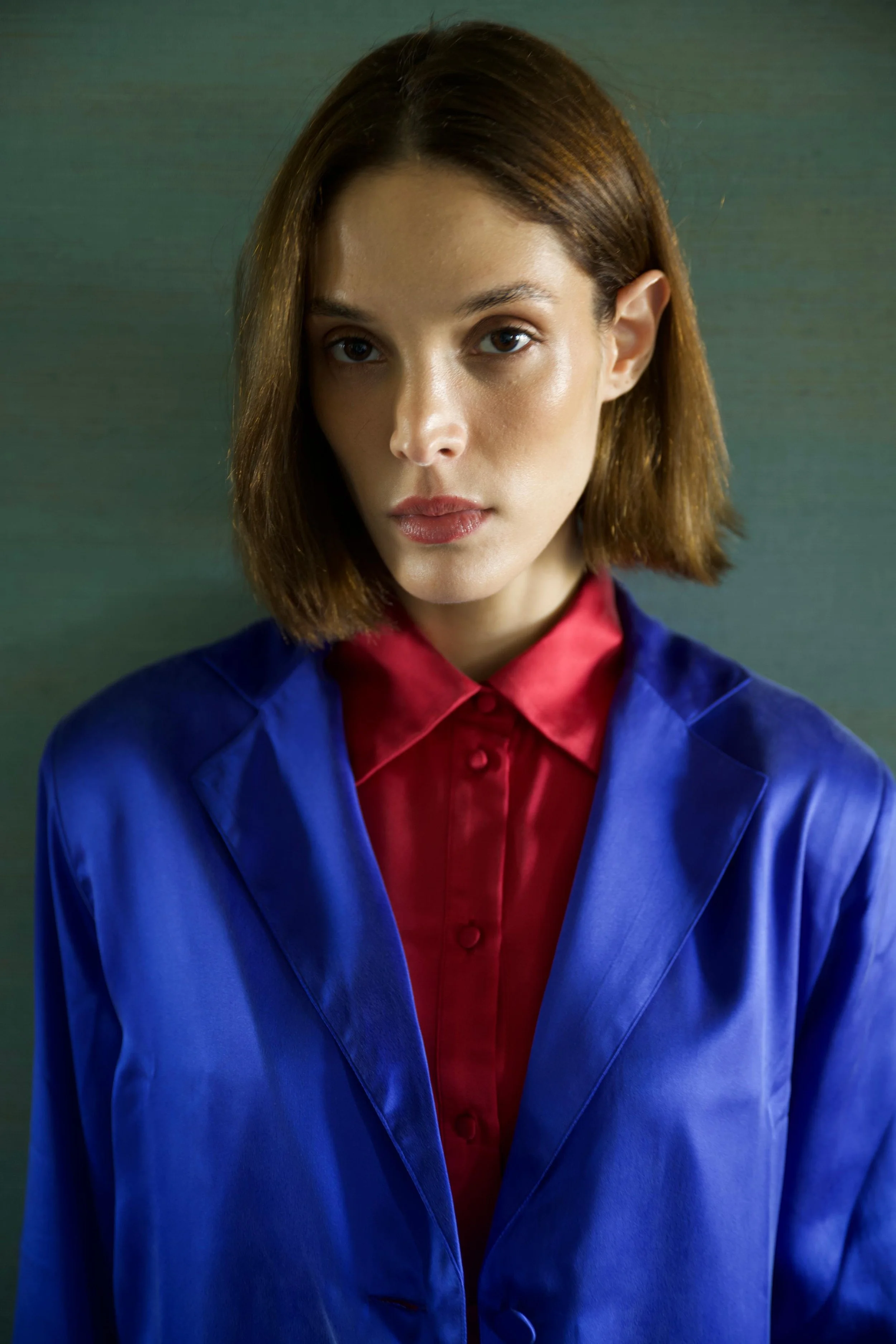 Close-up of woman wearing blue silk blazer over red shirt
