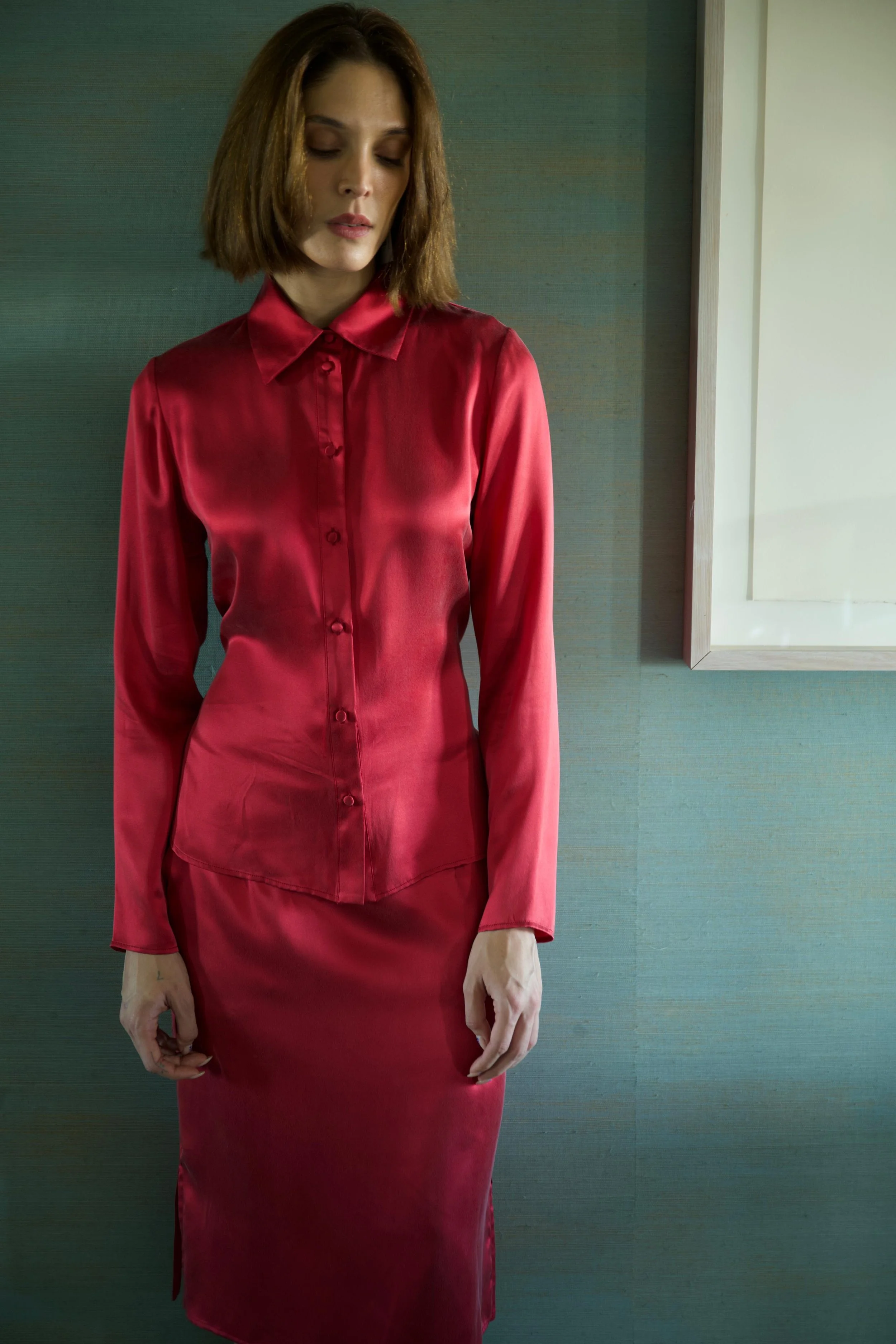 Woman wearing bordeaux silk shirt and matching straight skirt