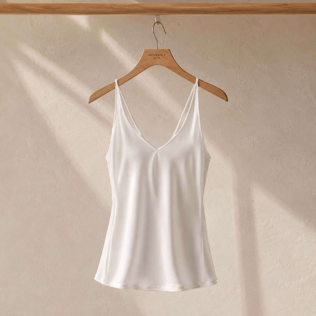 White silk camisole top on hanger
