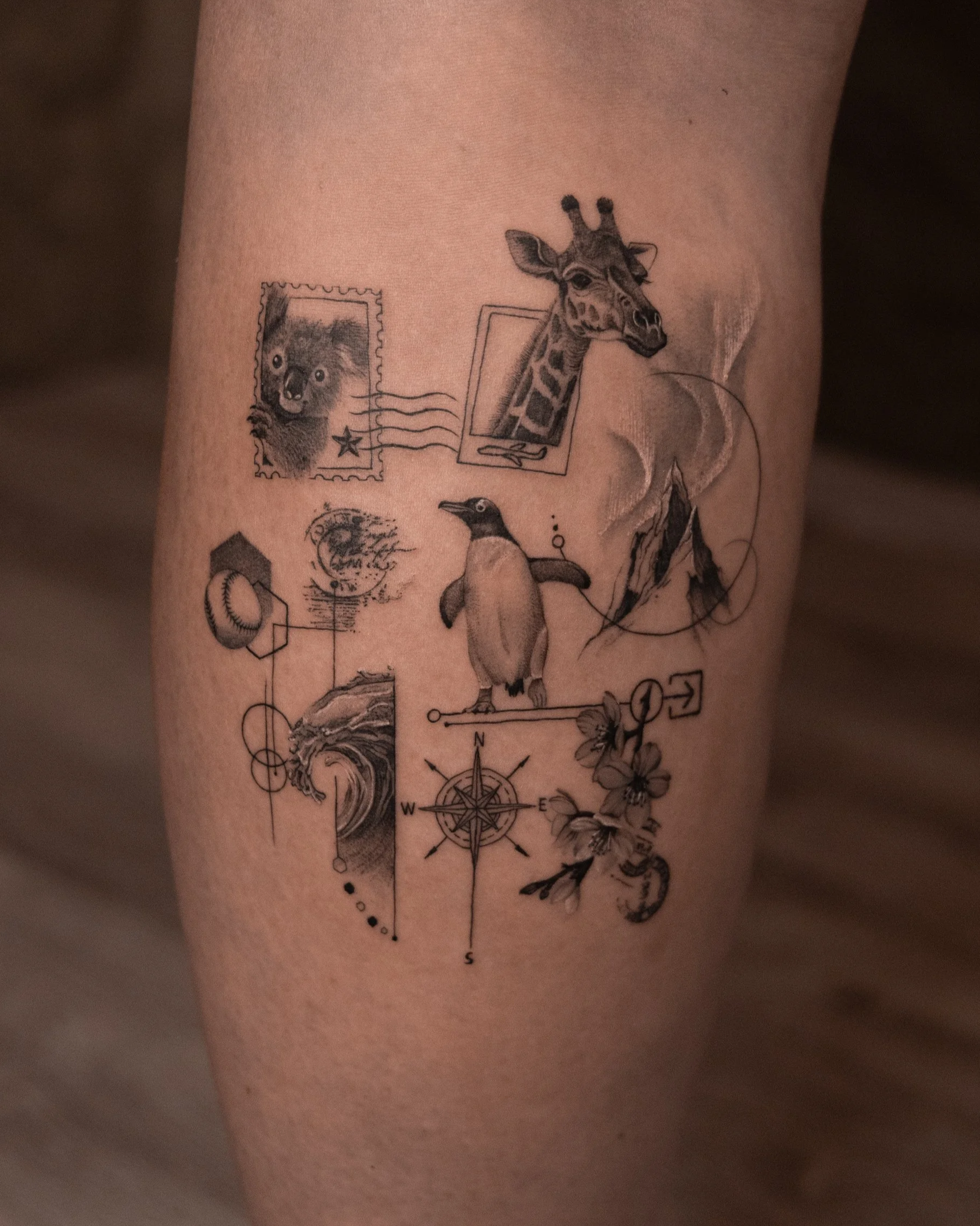 A tattoo featuring various animals, including a bear, giraffe, and penguin, along with other elements like a compass, mountain, flowers, and geometric shapes.