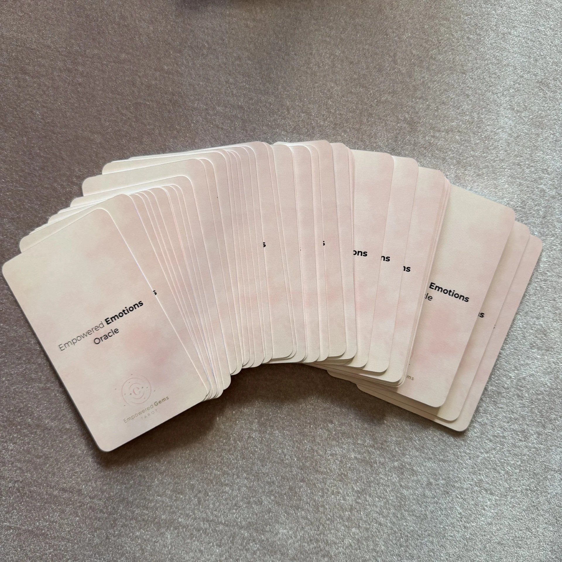 Empowered Emotions Oracle 70 card fan spread on mauve background.