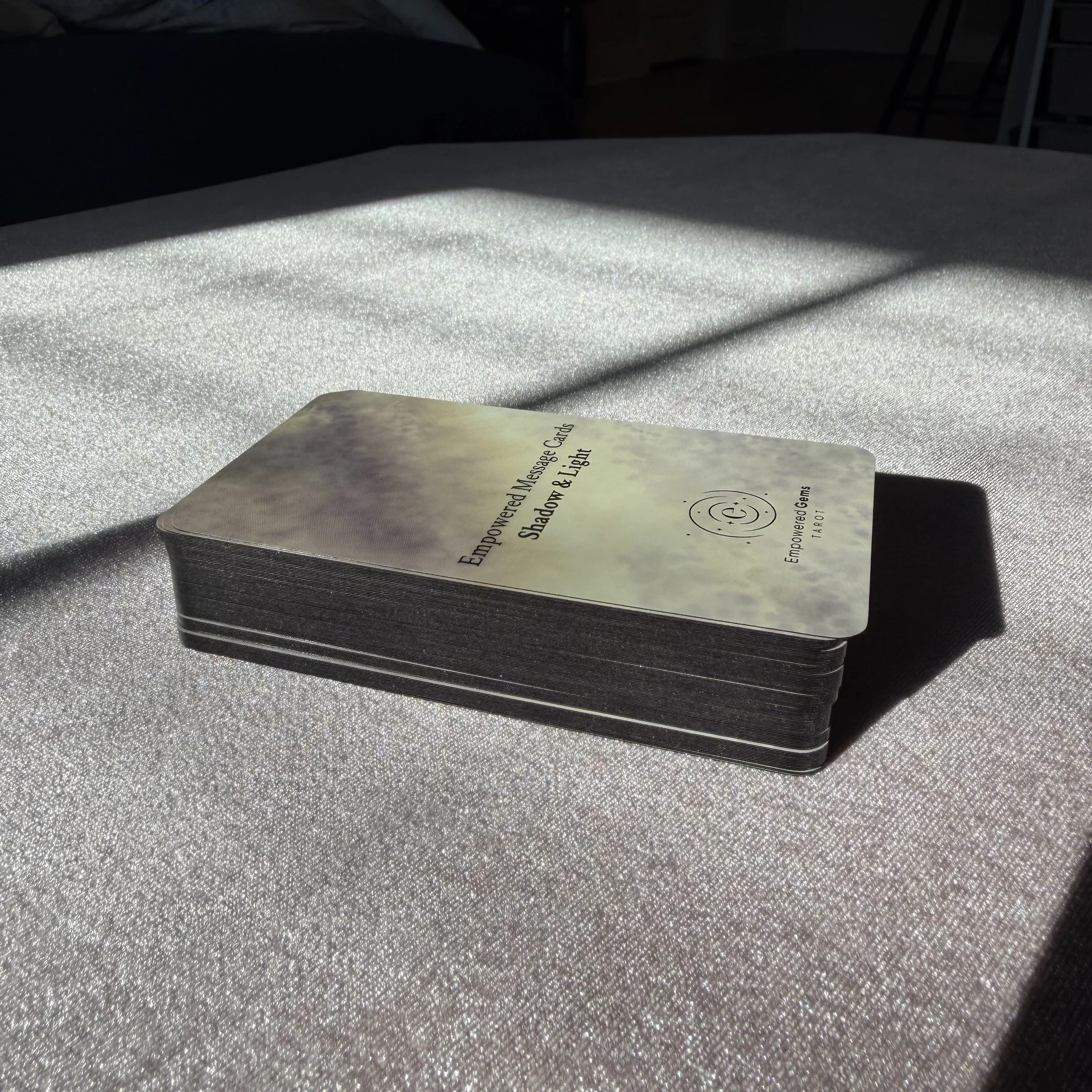 Empowered Message Cards Shadow and Light black gilt edge card deck in sunlight