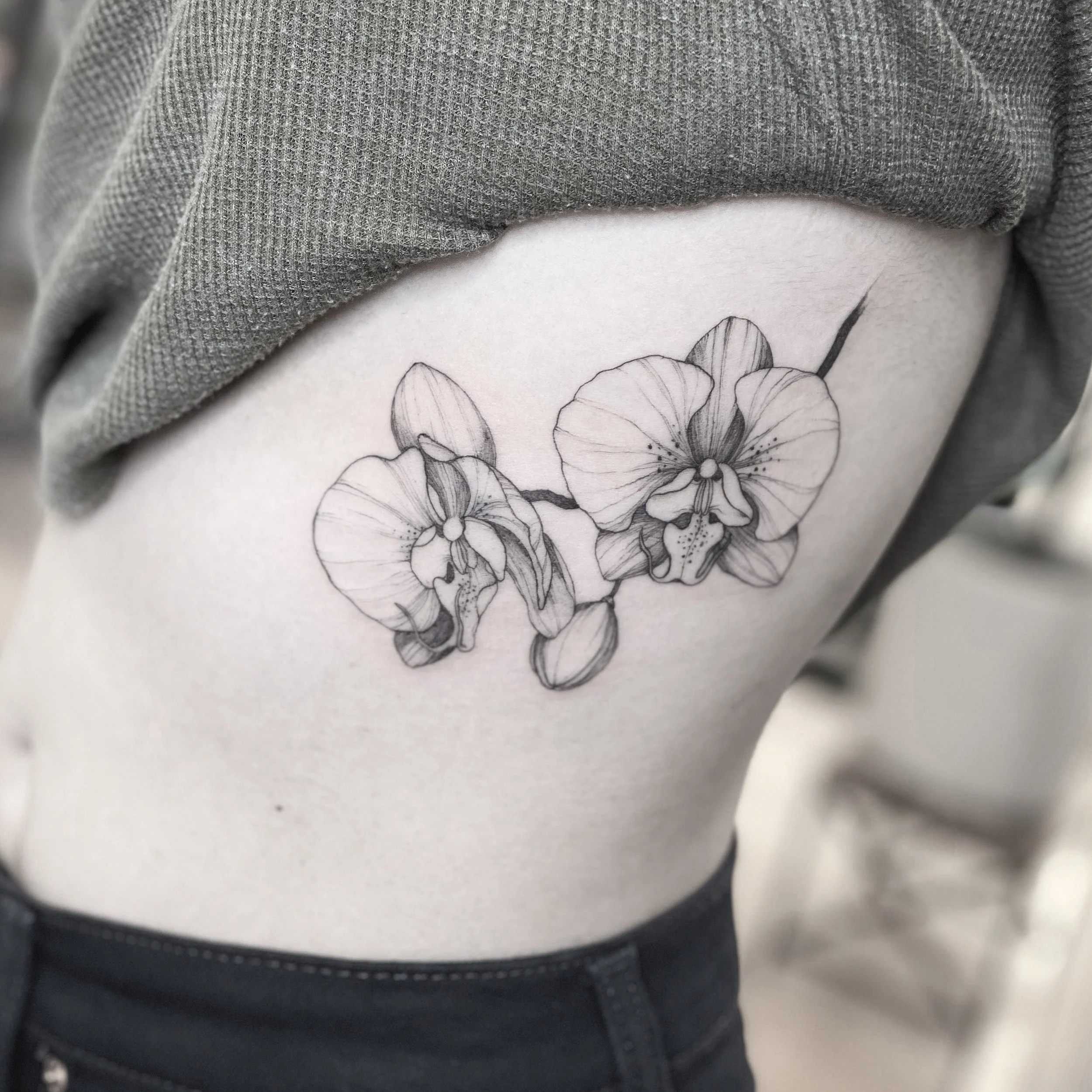 Best bay area fine line orchids flower tattoo on the ribs