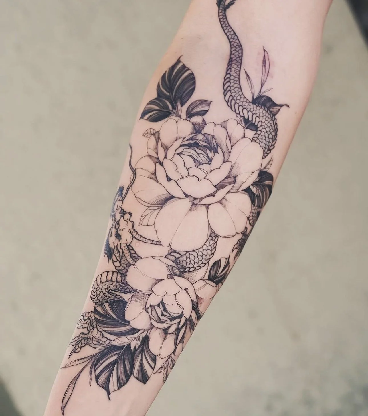 Traditional dragon and fine line peony flowers on arm