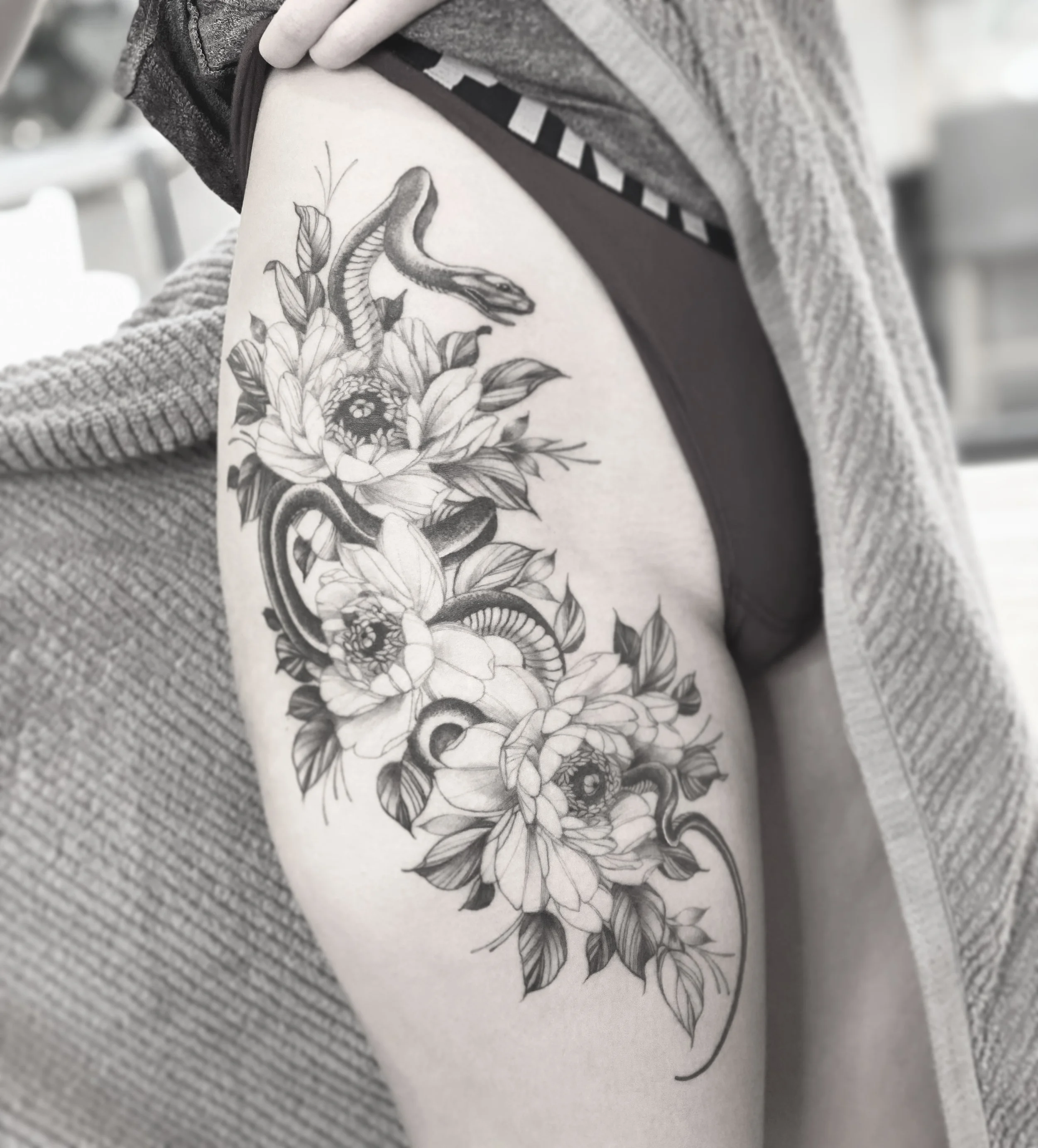 Best bay area fine line snake and flower tattoo on thigh