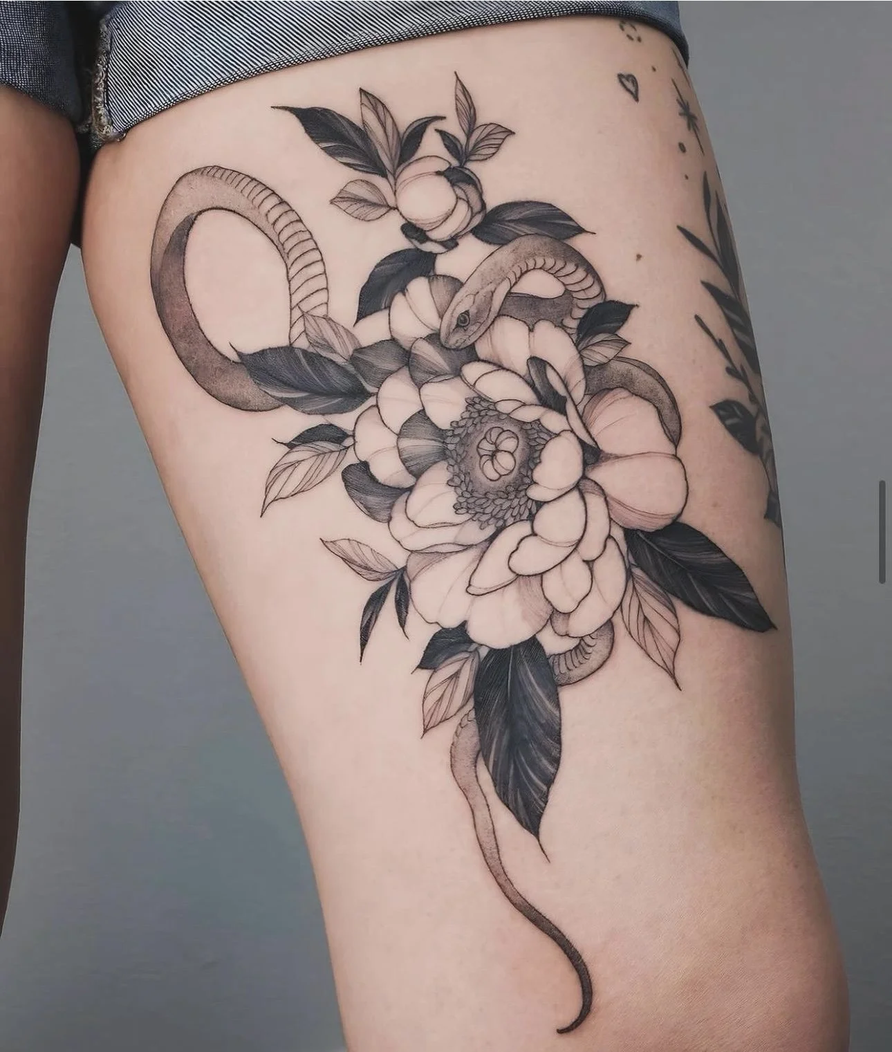 Fine line snake and peony flowers on thigh