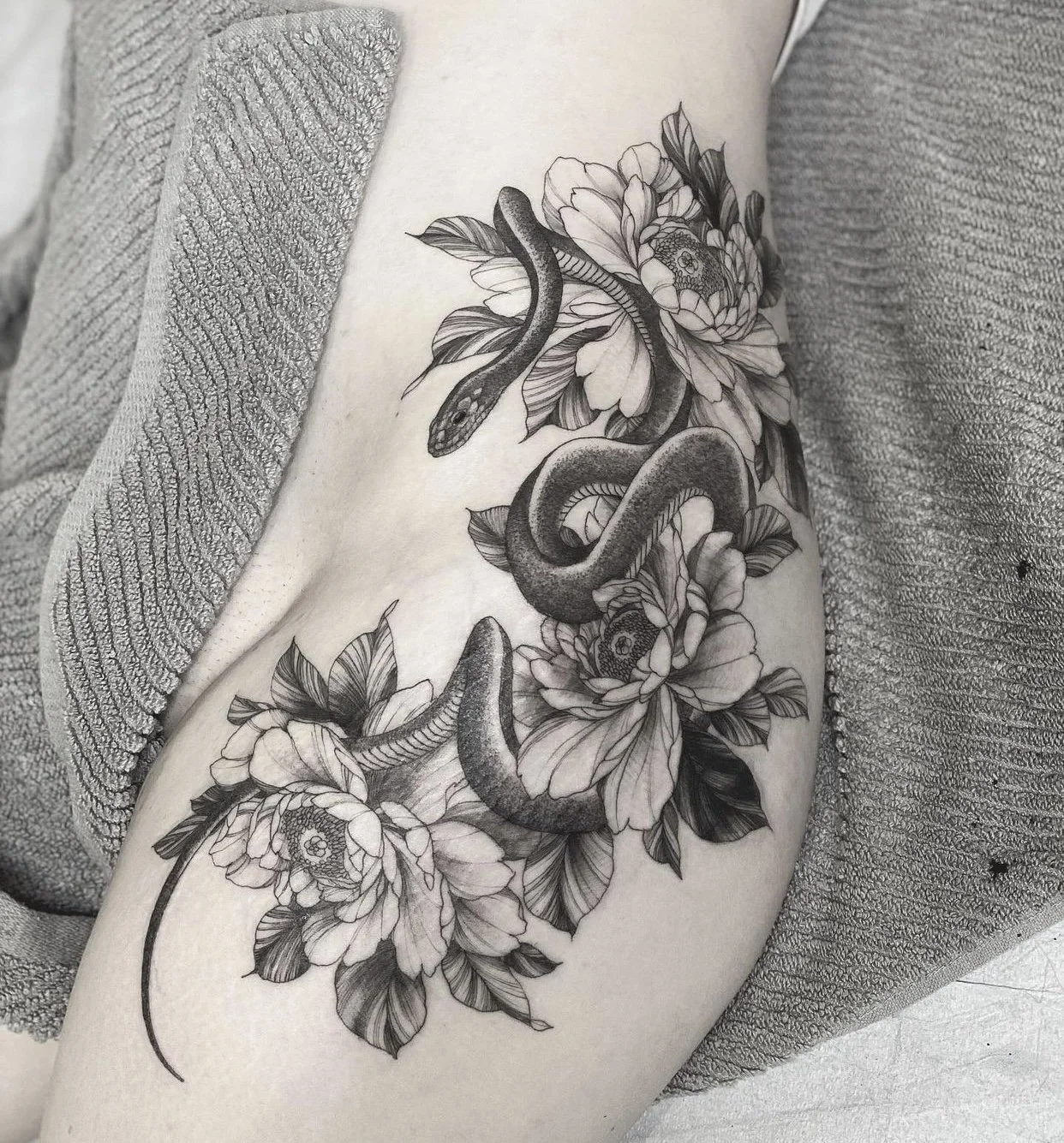 Best bay area fine line snake and flower tattoo on thigh and hip