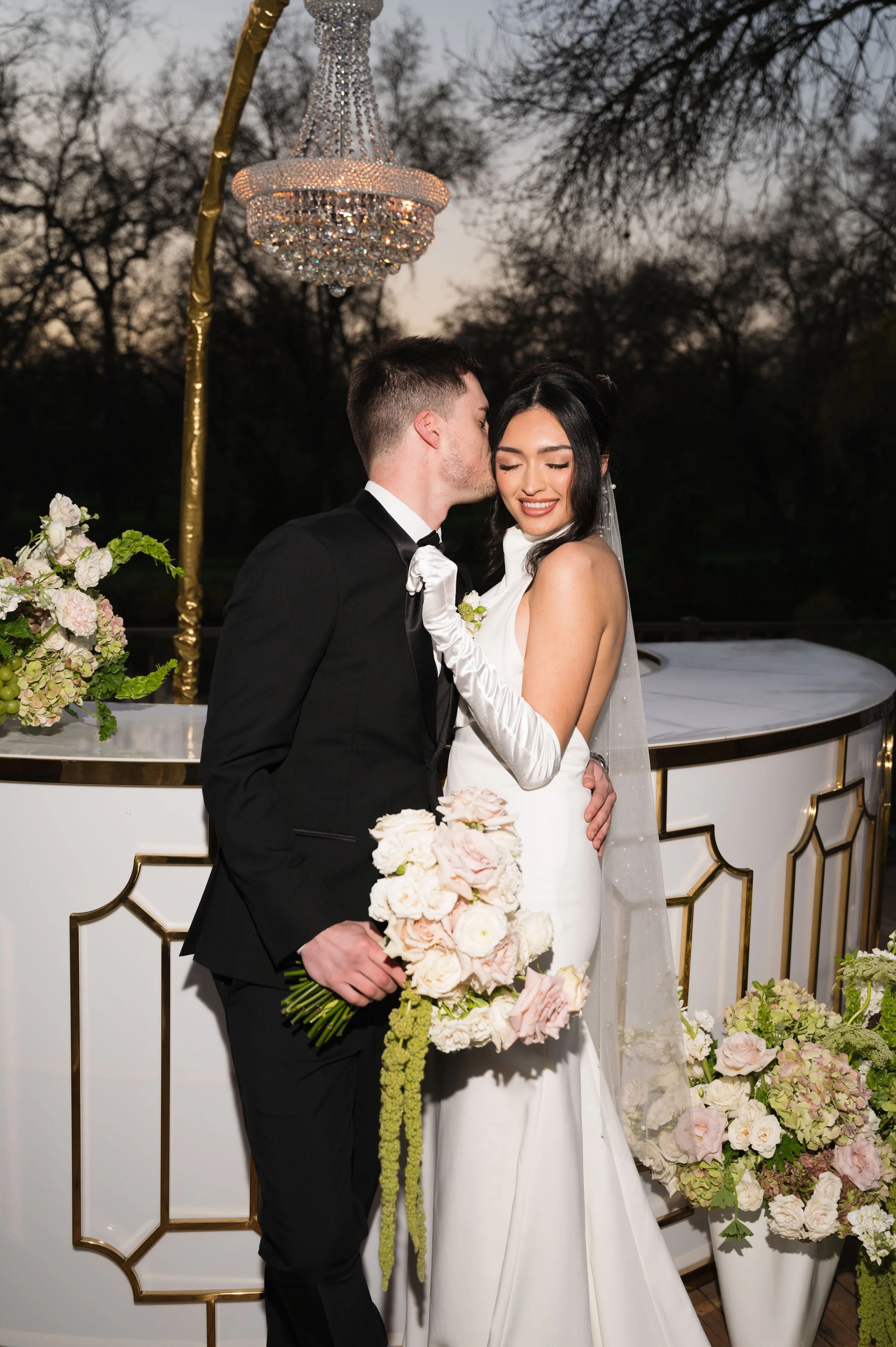 a couple bride and groom at swan lake deck area with a custom gold and white bar