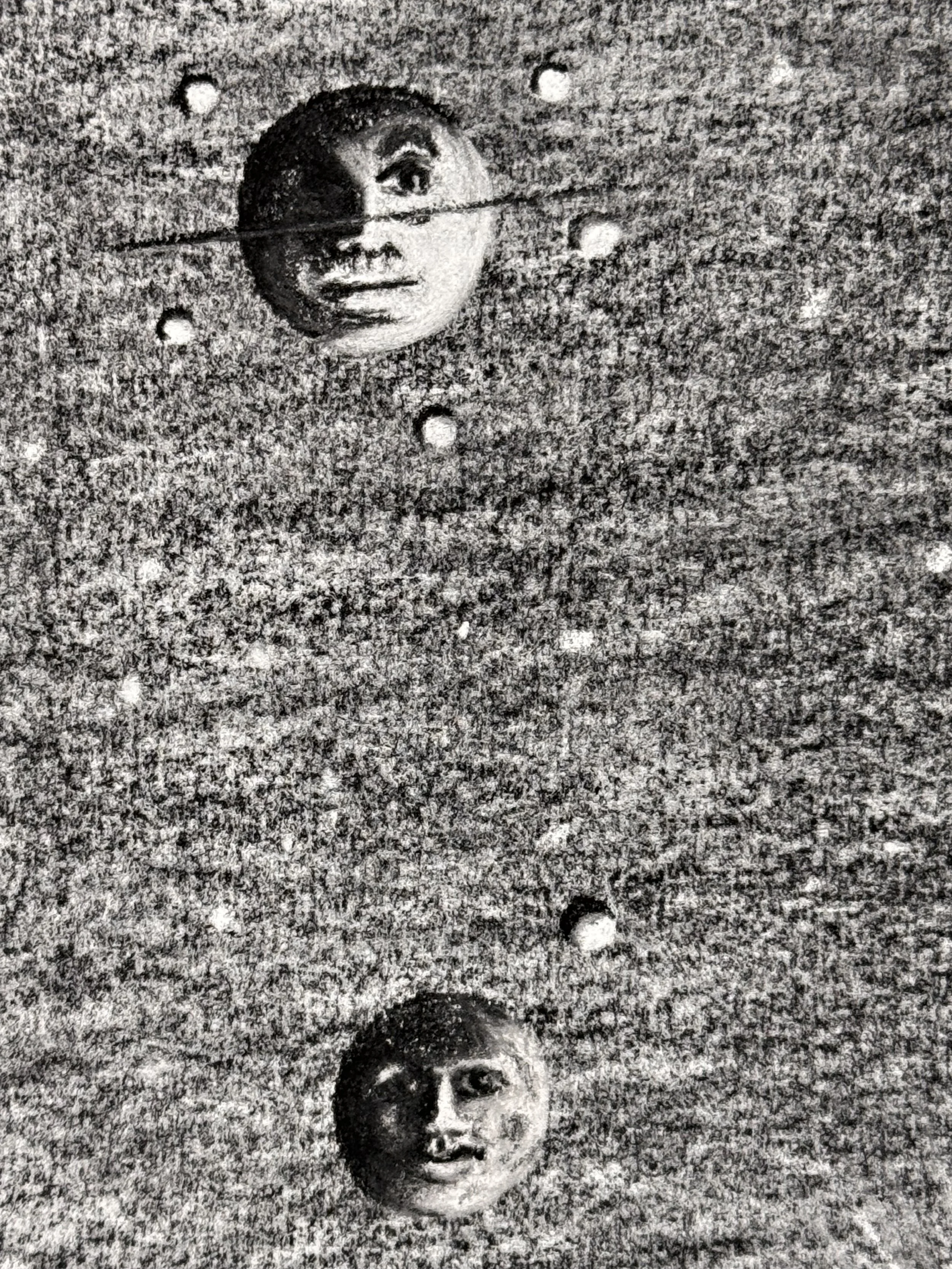 Close up of two floating moon faces in Celestial Reverie, showing surreal facial expressions and rich charcoal texture against a star filled background.