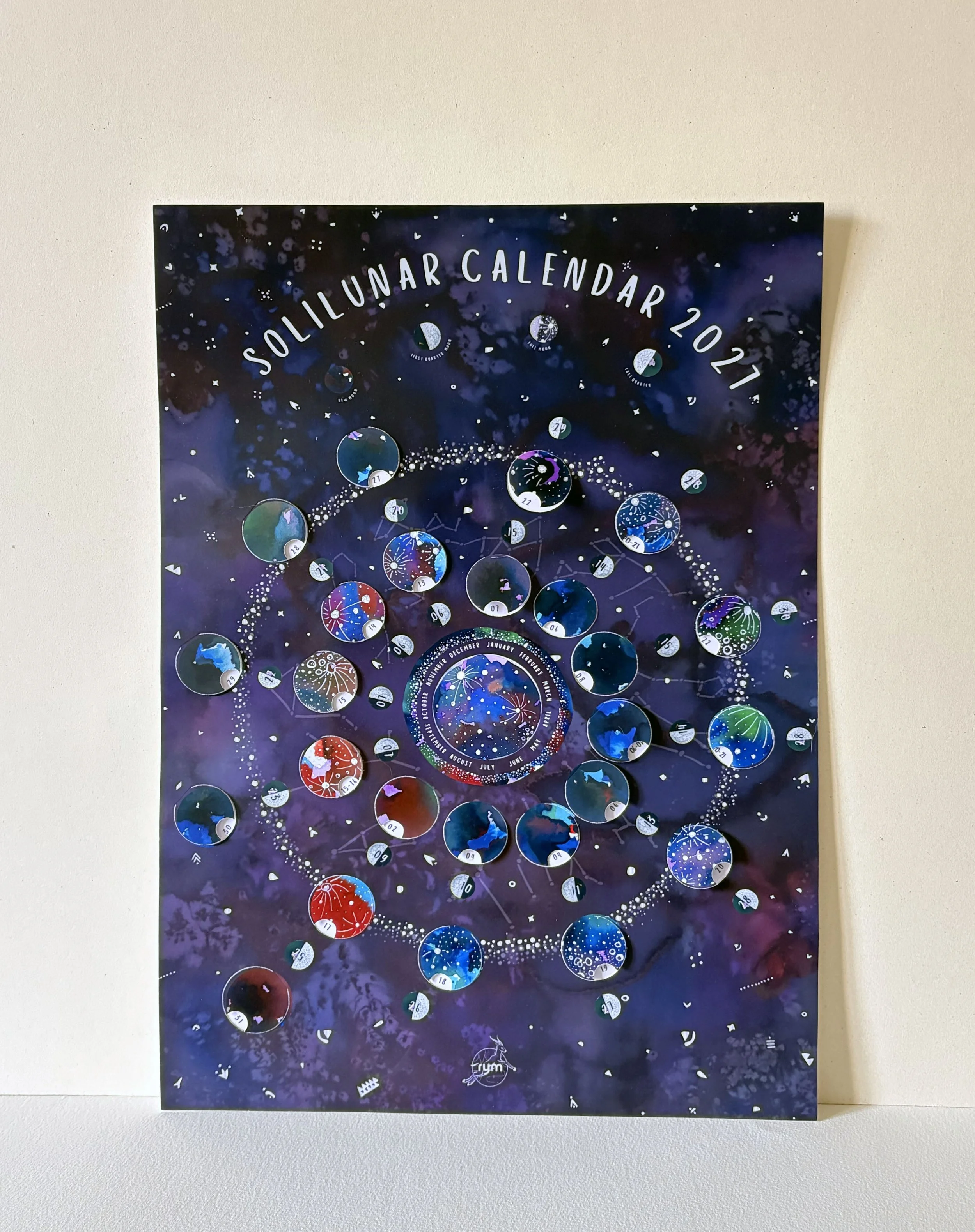 Full view of the 2027 Moon Calendar against a plain white background, showing its A3 portrait format, purple starry design and colourful illustrations of the lunar phases.