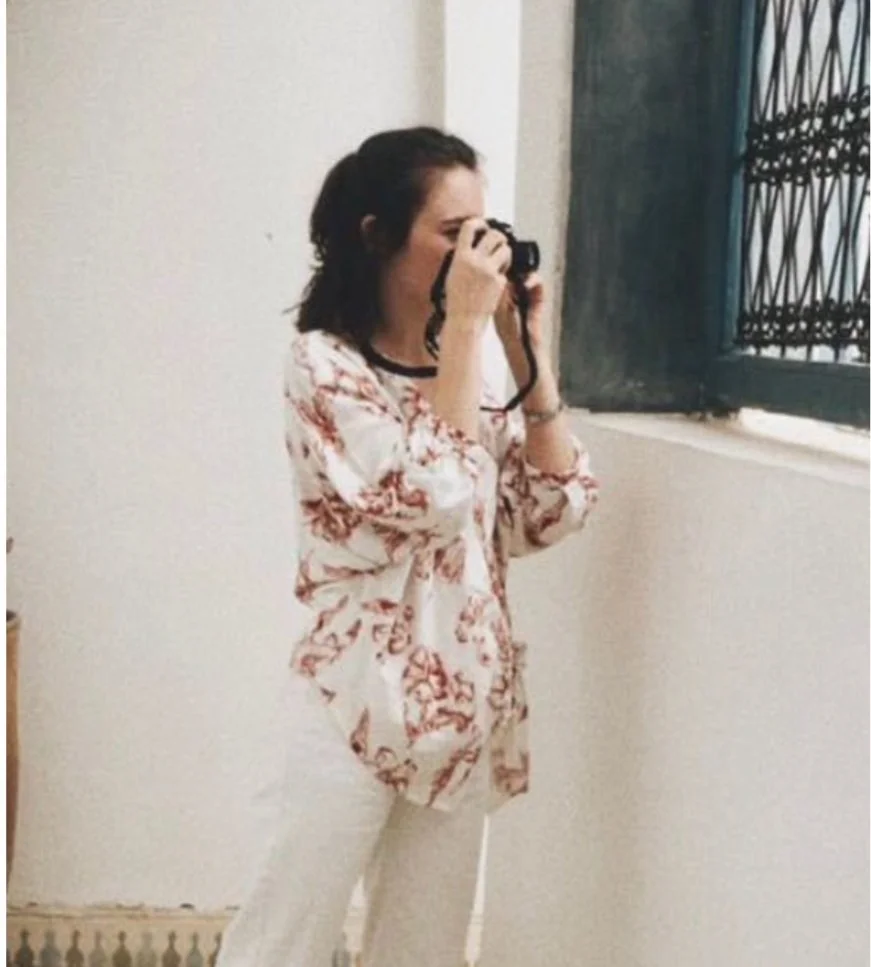 Woman looking serene taking a photo through a window