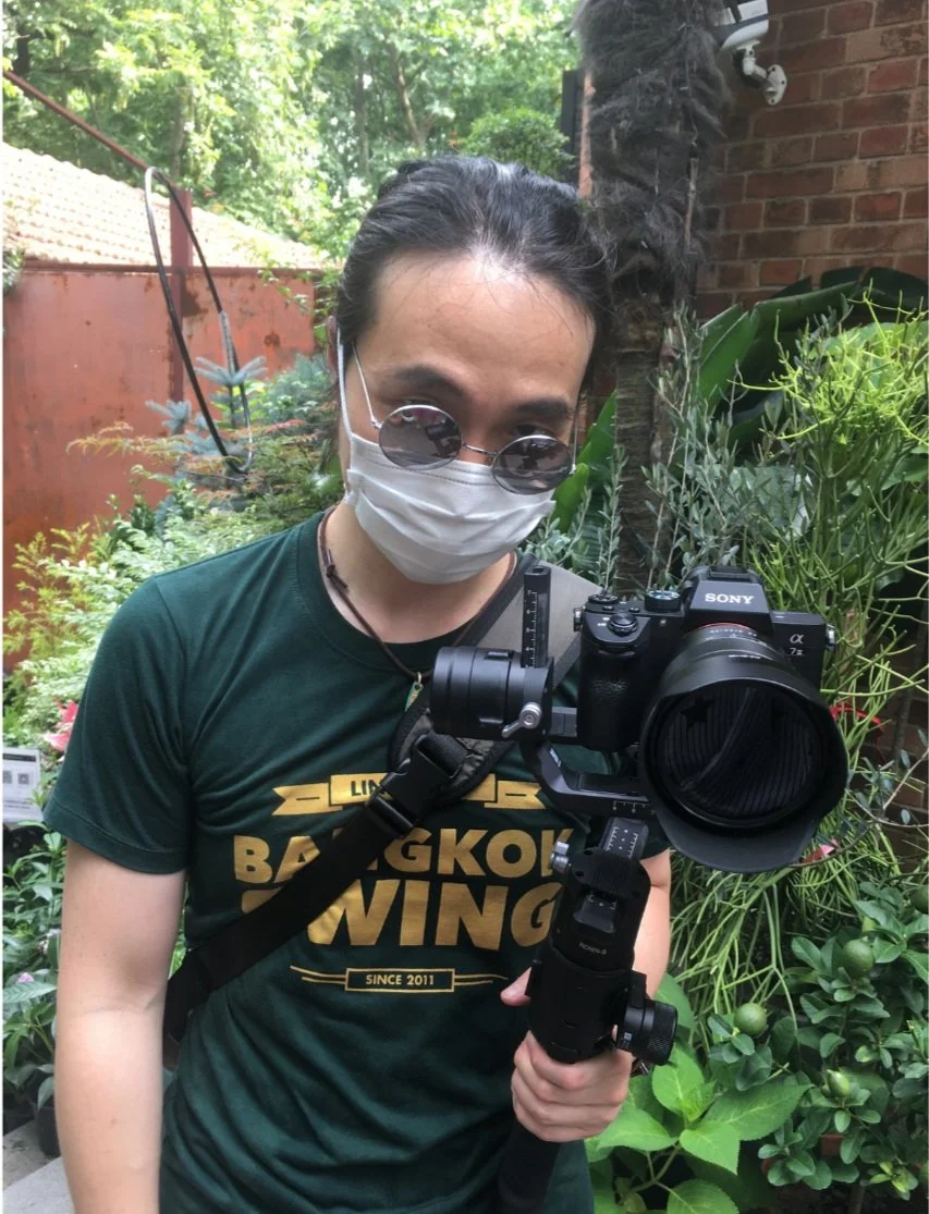 Man focused on his camera, wearing a mask and glasses