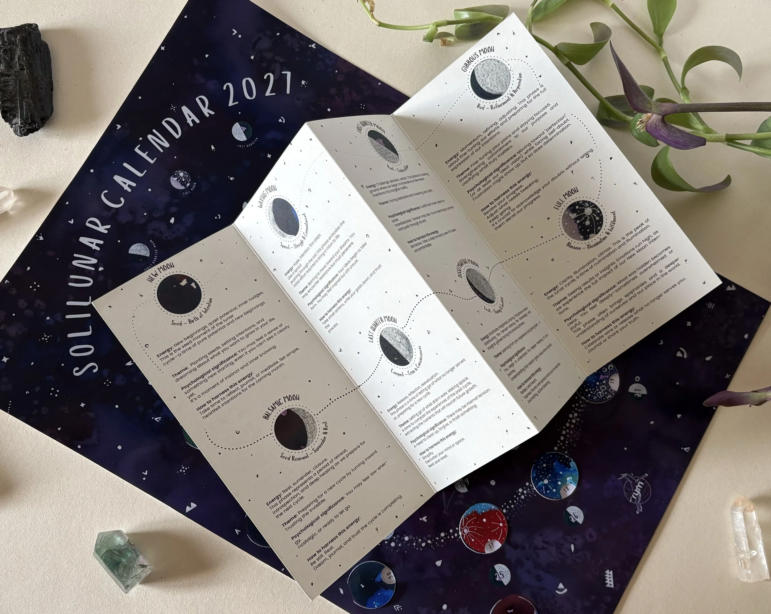 Flatlay of the 2027 Moon Calendar alongside the Moon Companion Guide, showing the different phases of the moon and their meaning.