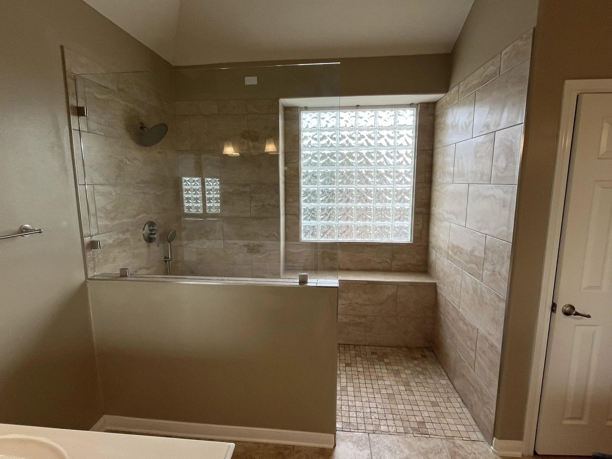 Barrier-free walk-in shower with natural light and safety modifications in Houston home