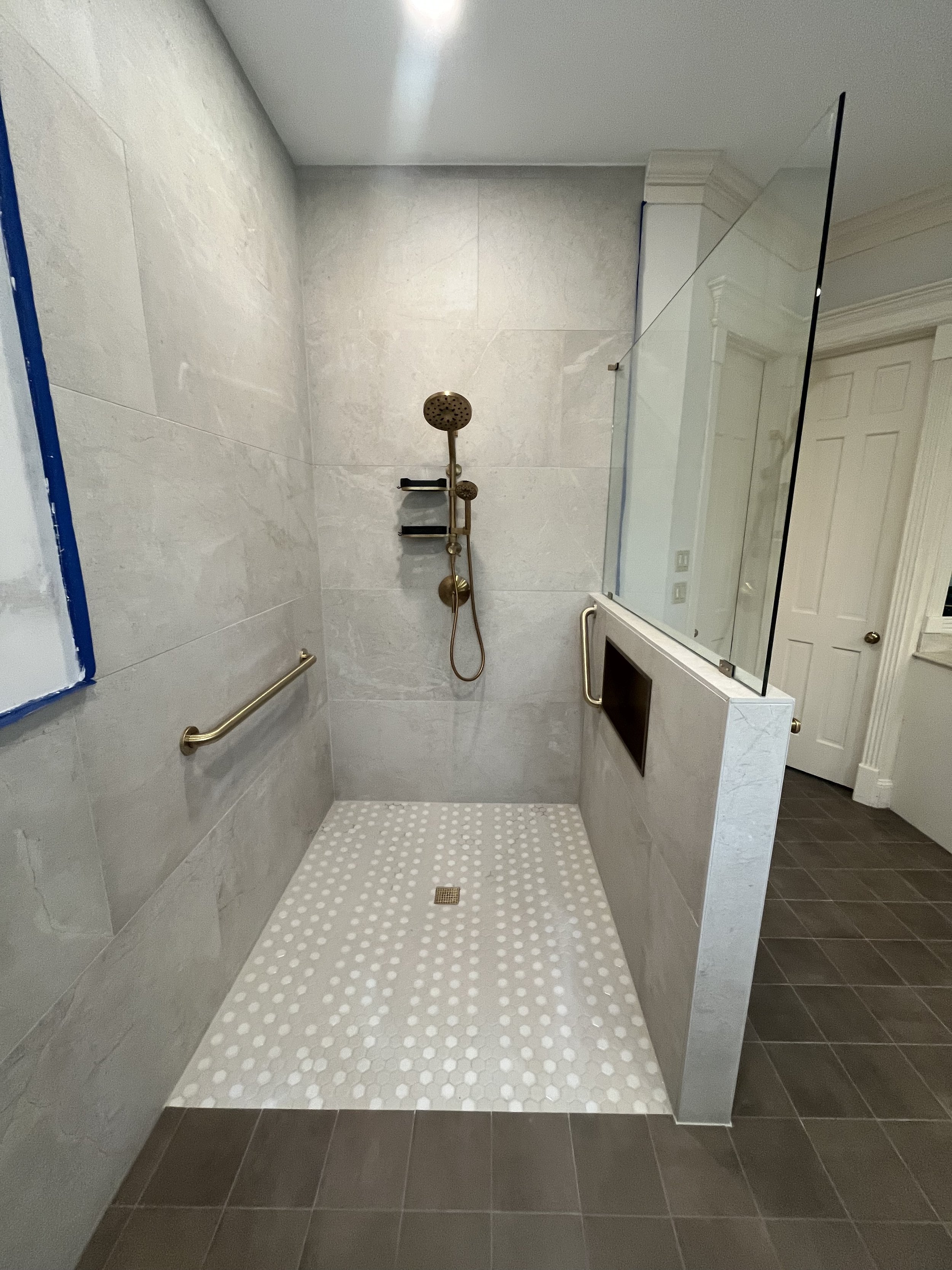 Accessible shower with grab bar and fold-down bench in Houston home