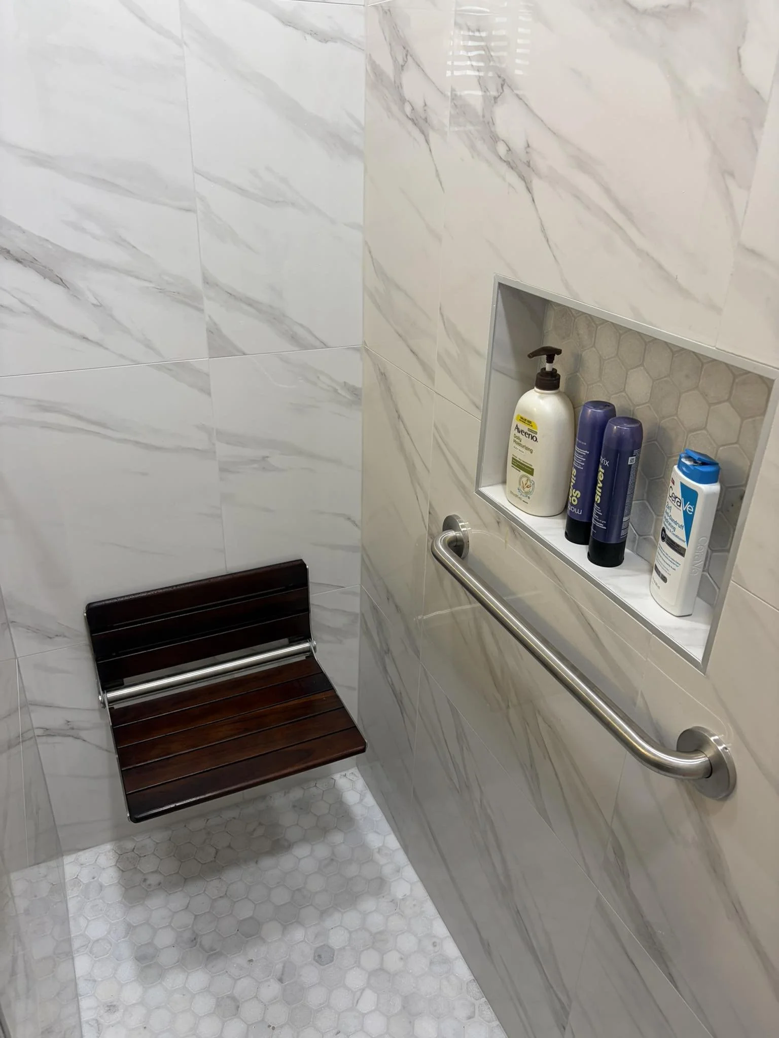 Grab bar placement in walk-in shower with bench for safety and accessibility Houston home
