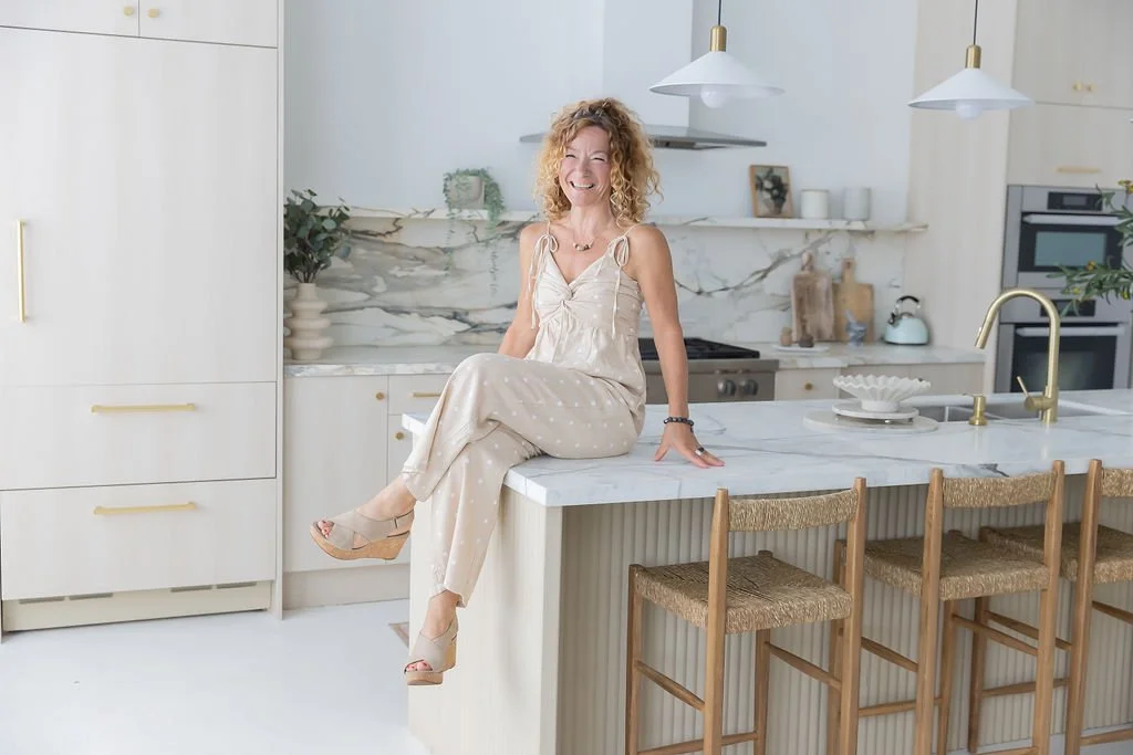 Shelley O'Connor sitting on a kitchen island, smiling