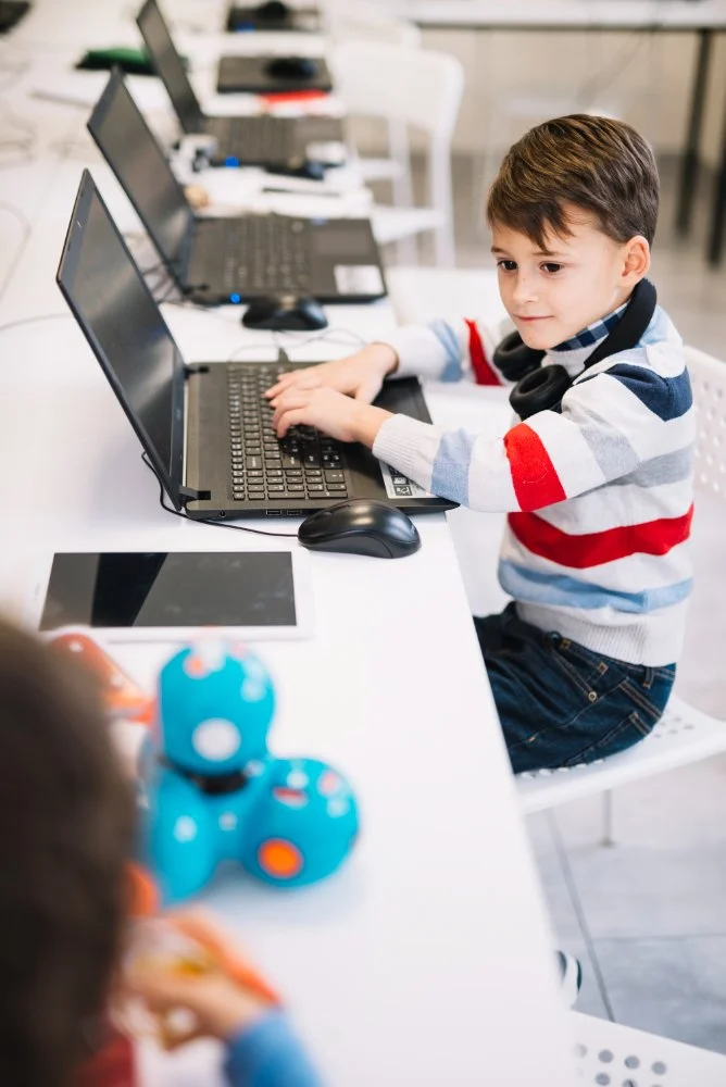 Young student focused on a coding project during a classroom session with tech-learning toys.