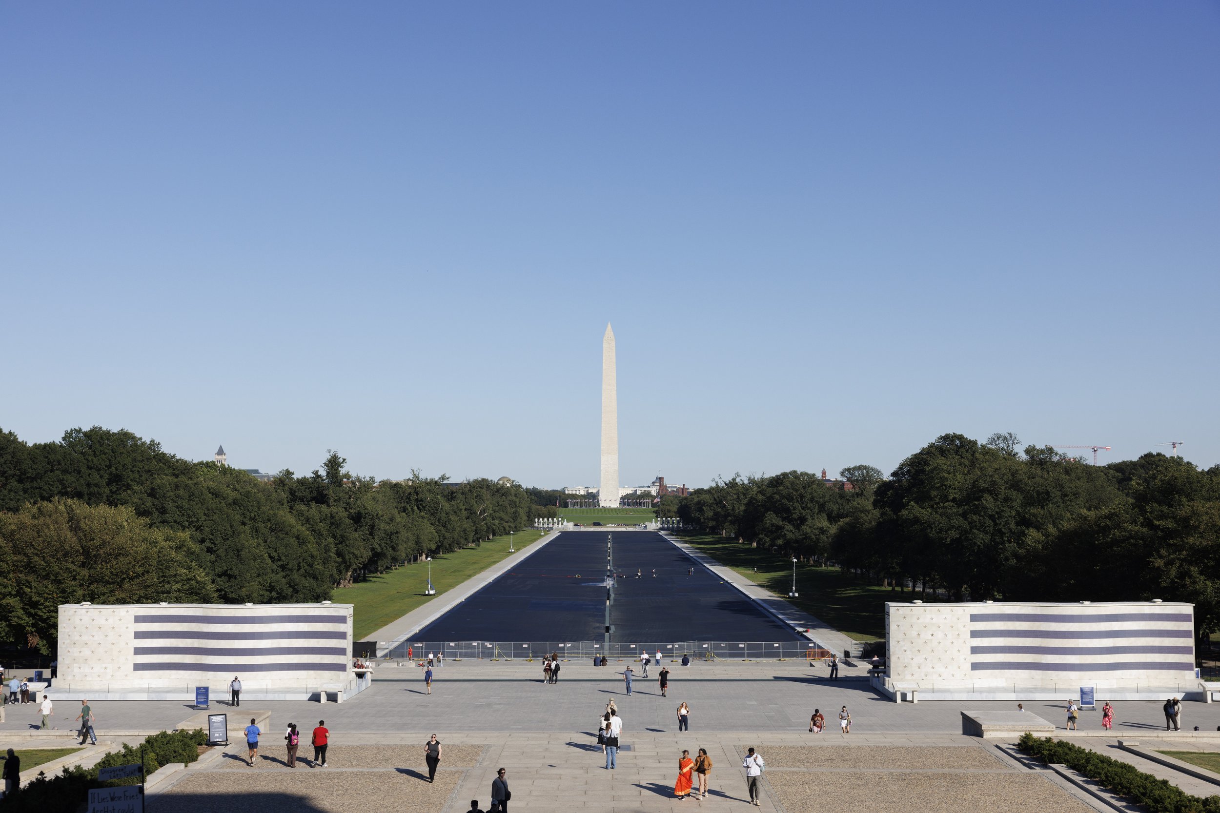 WASHINGTON — Workers continue repairs at the Lincoln Memorial Reflecting Pool as visitors gather near the monument on Oct. 7, 2026, with fencing surrounding the pool ahead of its expected reopening later in the week. (Liz Helgesen)