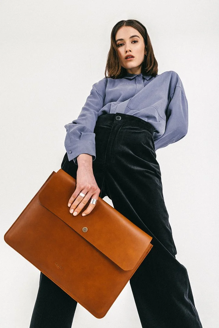 Fashion model holding a brown leather portfolio