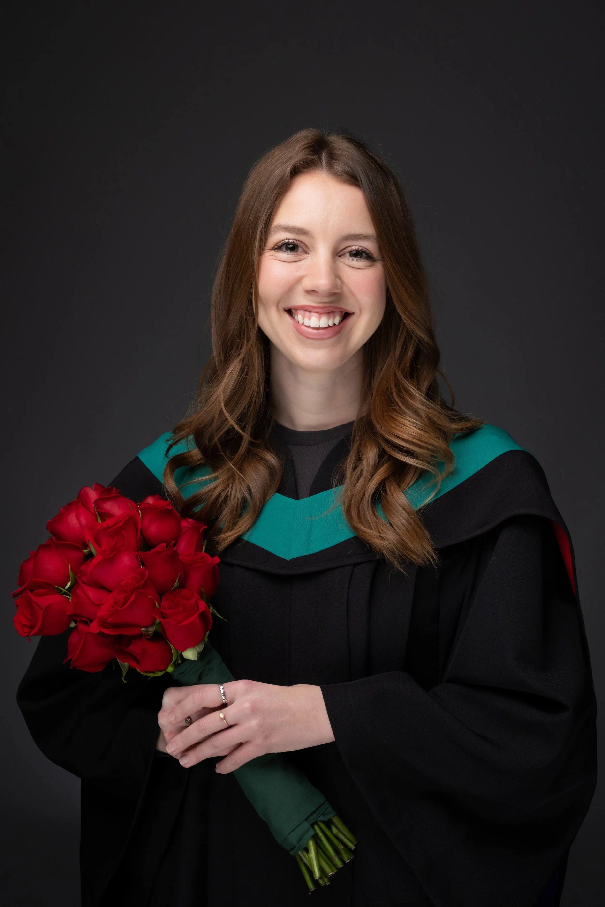 TRU graduate holding red roses