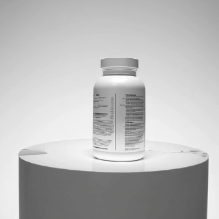 Envase blanco de suplemento dietético sobre una superficie redonda.