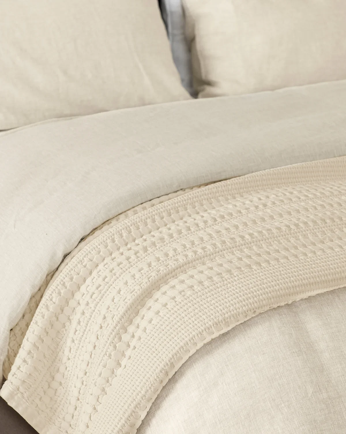 Cream waffle texture blanket on a bed with cream bedding from McGee & Co