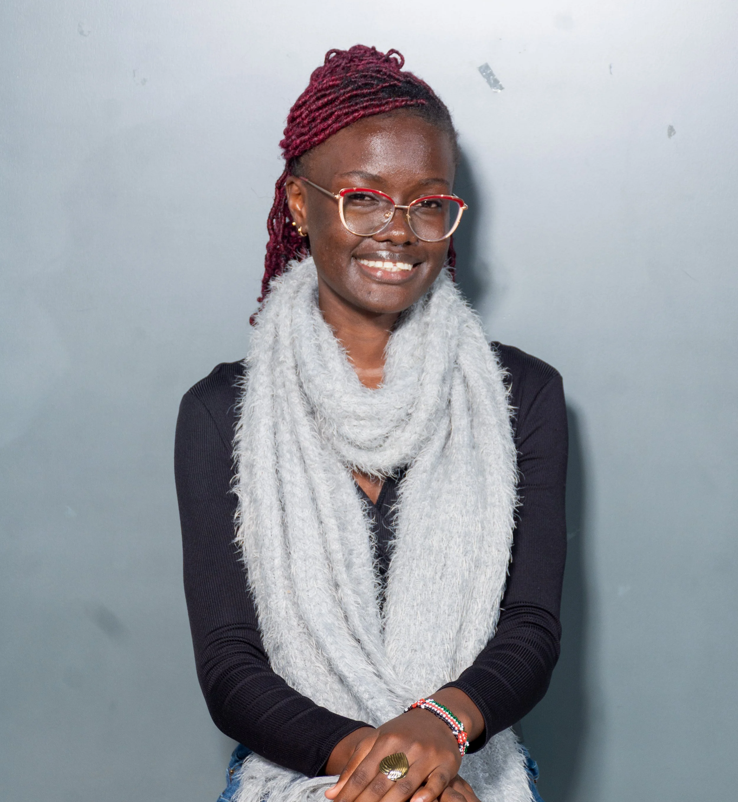 Esther KamiLimu Cohort 10 mentee in a grey suit and red tie posing for a formal portrait