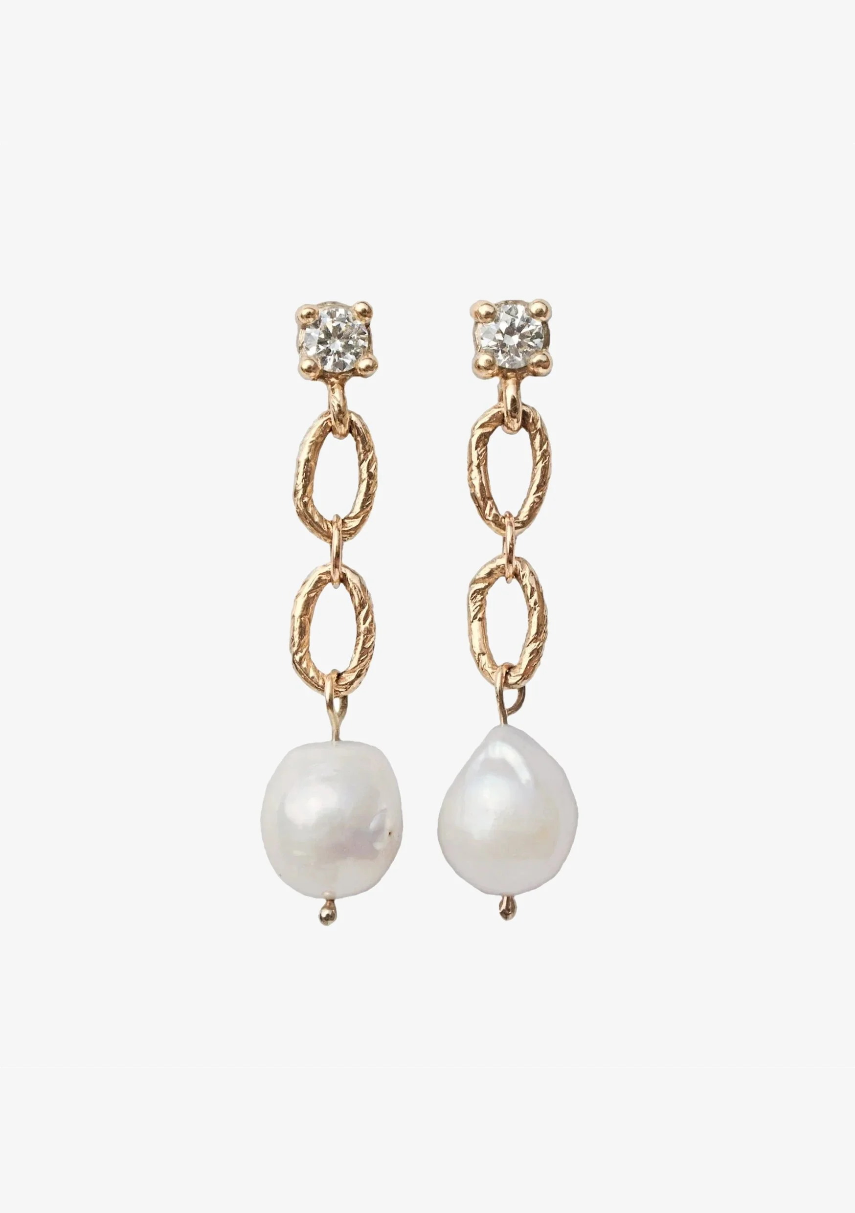 Gold and silver dangling earrings with a round pearl at the bottom and a small clear gemstone at the top.