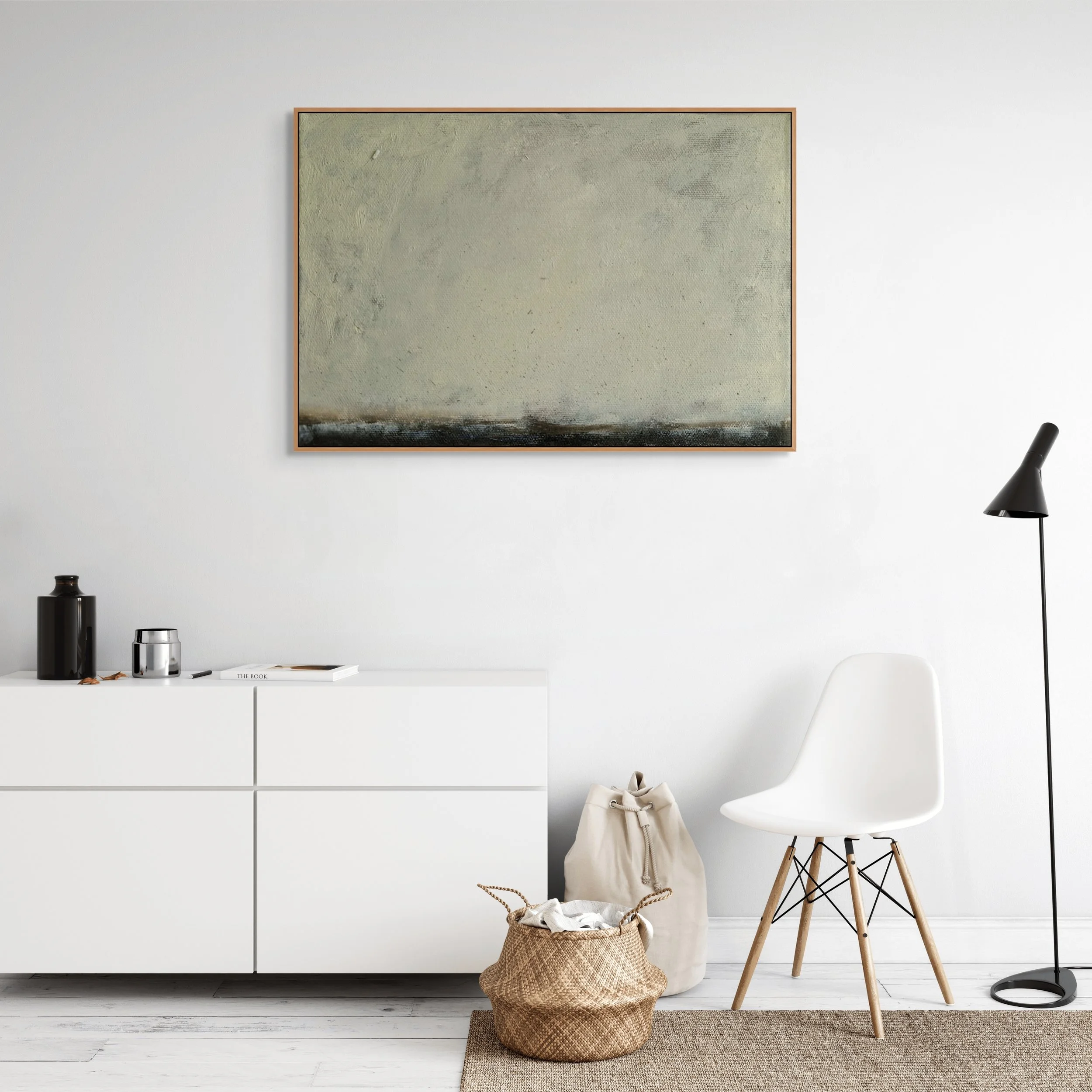 Minimalist living room with a white sideboard, abstract painting, white chair, black floor lamp, and decorative bags.