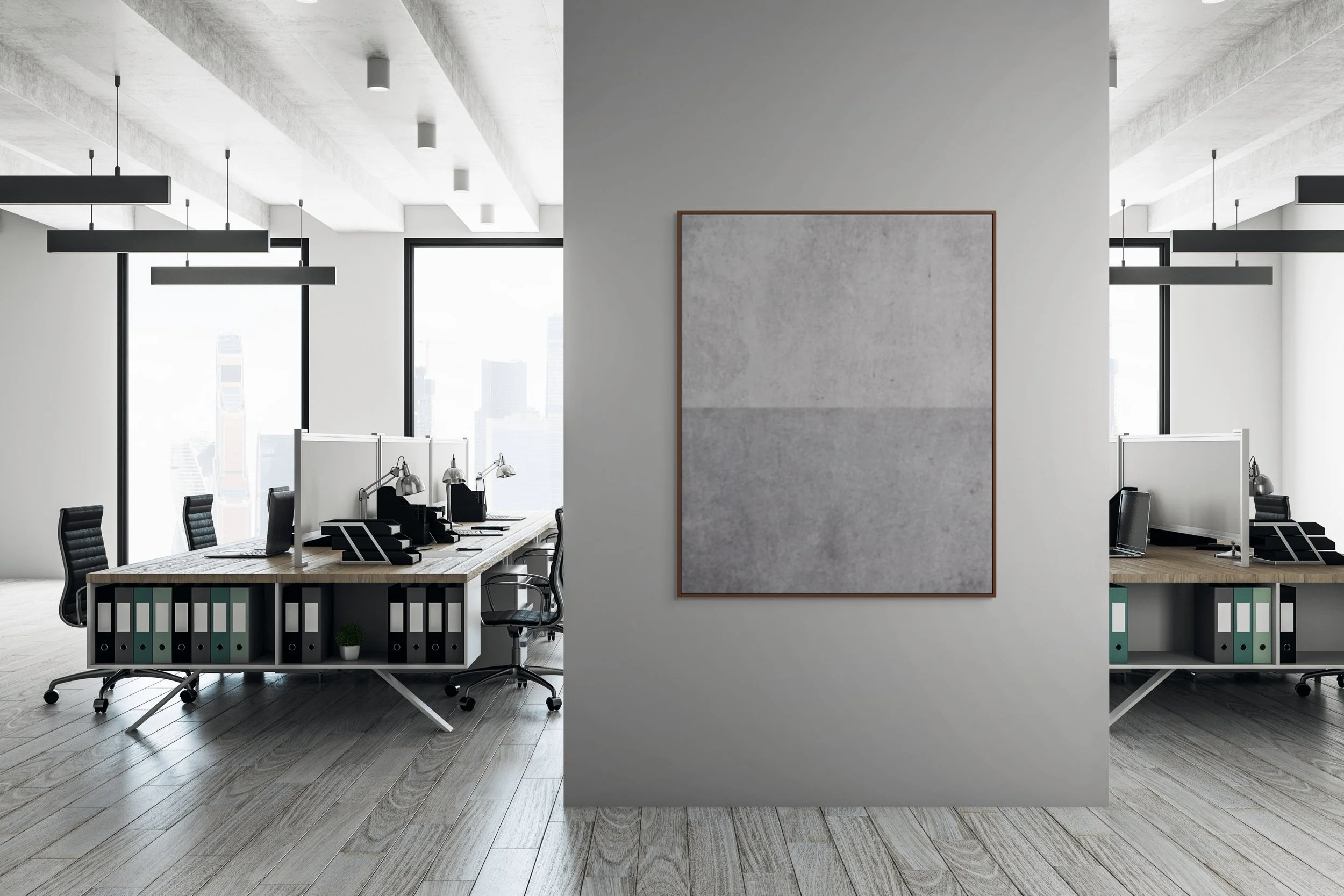 Modern office with two workstations separated by a wall with blank gray artwork, large windows with city views, black chairs, and office supplies.