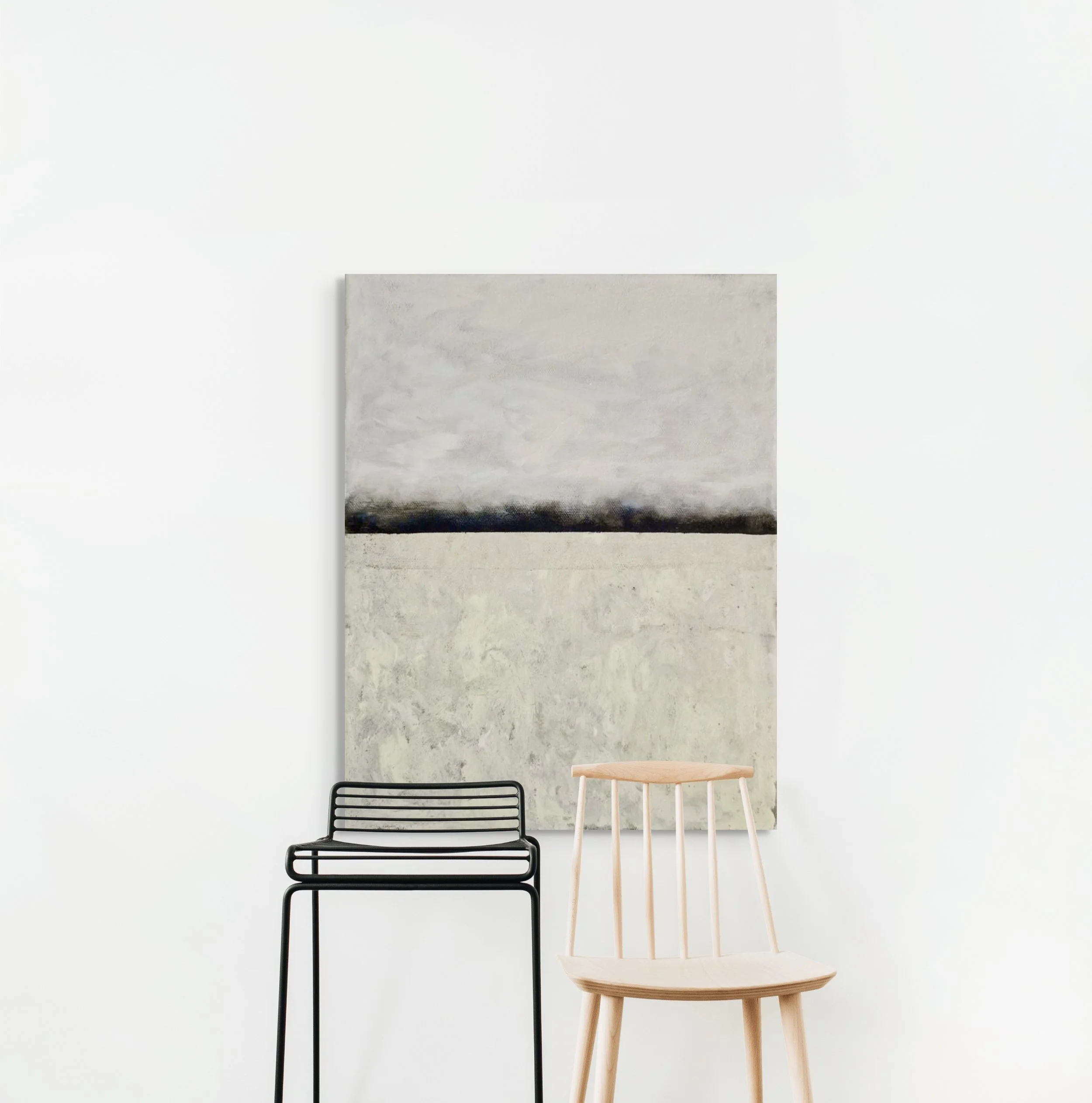Minimalist interior with a large abstract painting, a black metal chair, and a light wood chair against a white wall.