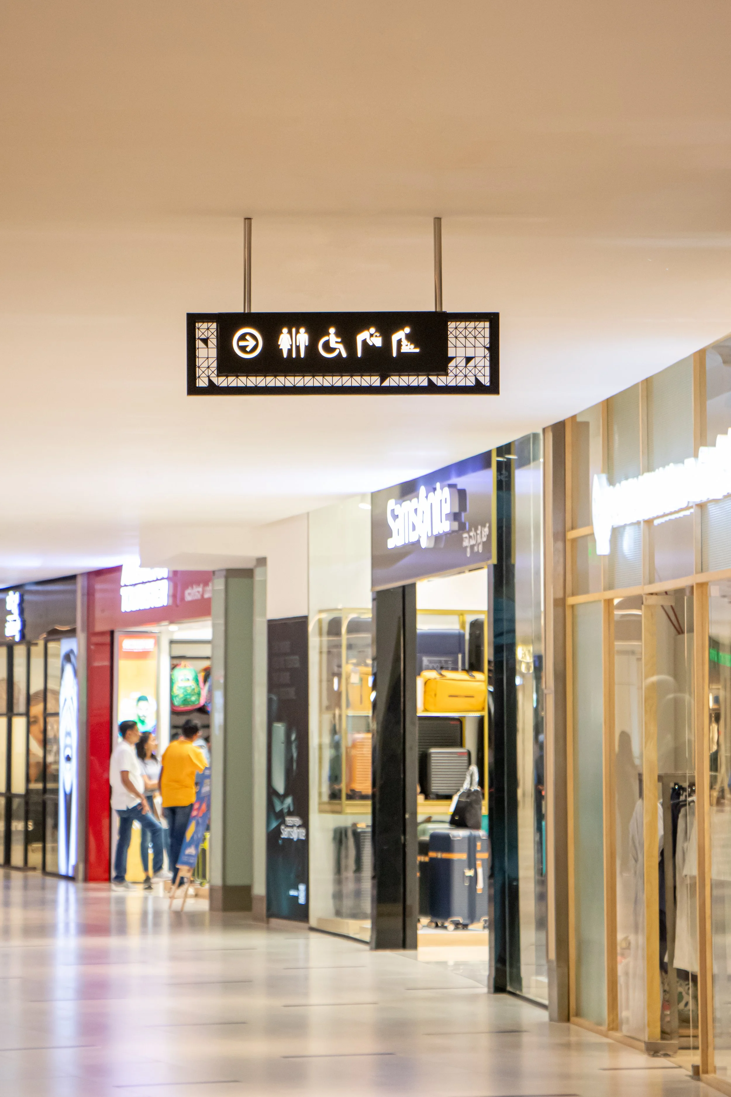 Signage at an airport indicating directions for restrooms, accessible facilities, showers, and seating.
