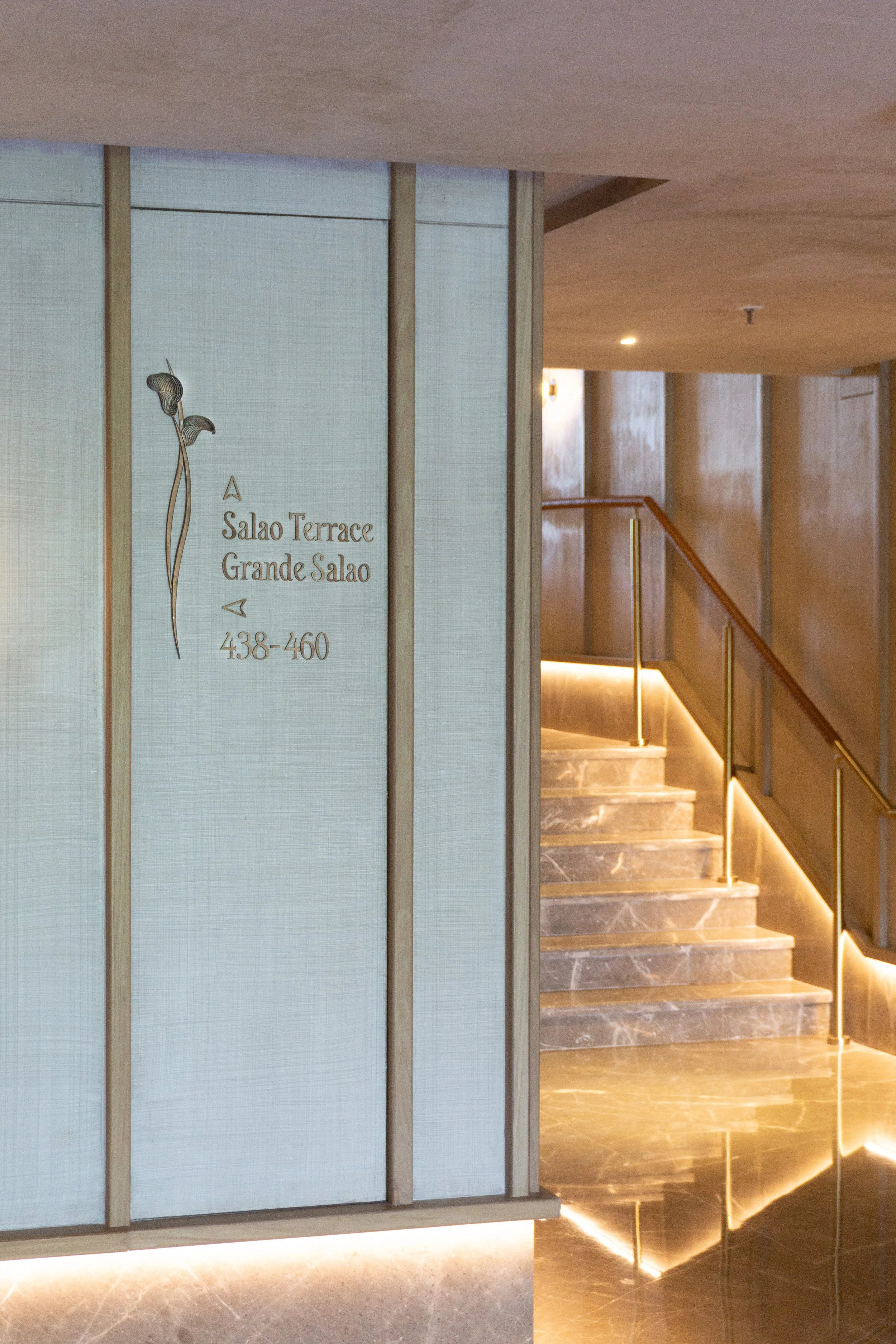 Sign indicating directions to Salao Terrace and Grande Salao, with room numbers 438-460, next to a staircase in a modern, well-lit interior.