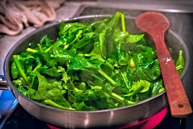leafy greens lightly stir-fried in the cooking pan on a stove