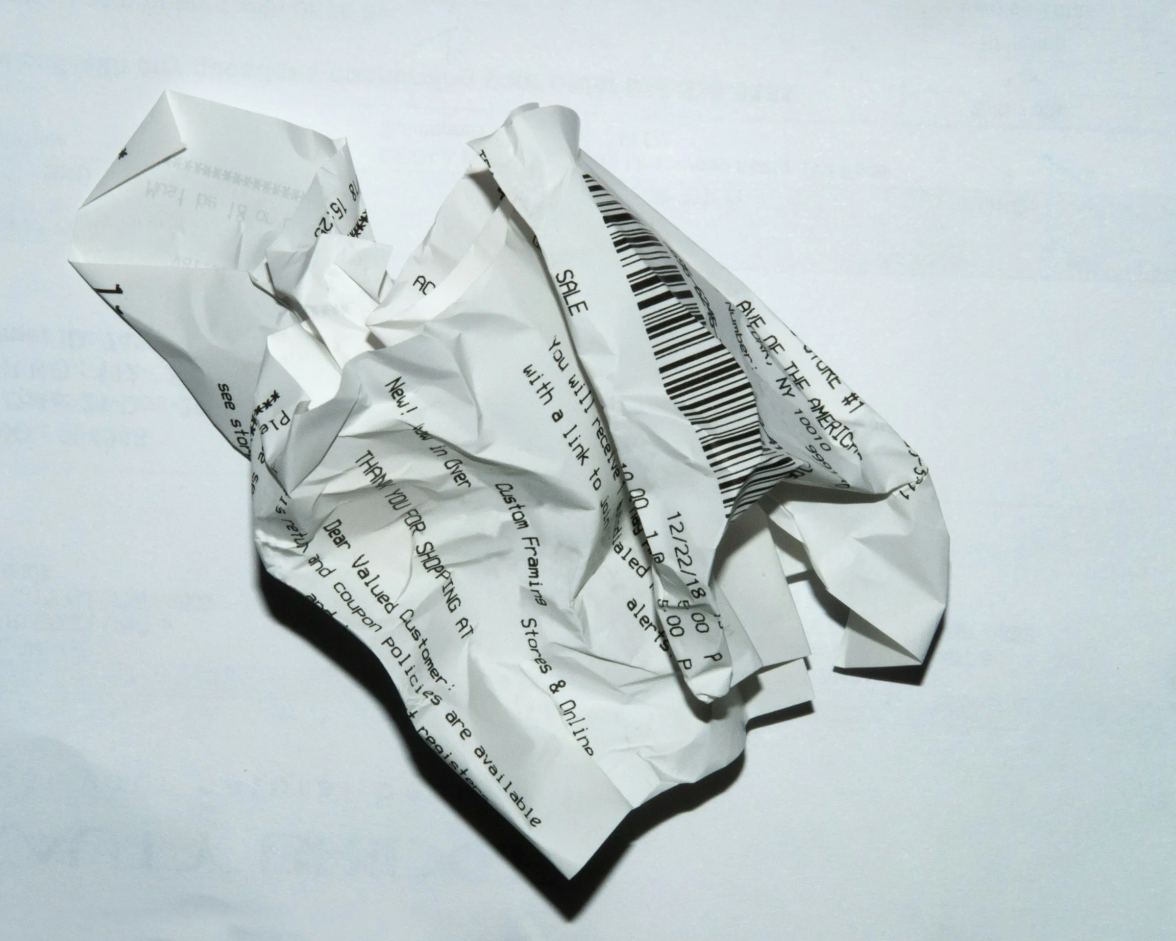 A close-up photo of a crumpled thermal paper receipt — a common source of BPA exposure in everyday life