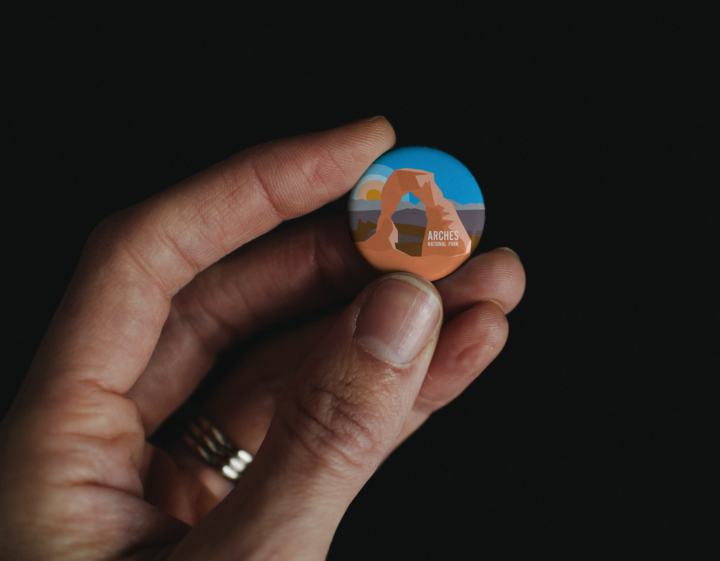 Hand Holding Pin Button Mockup.png