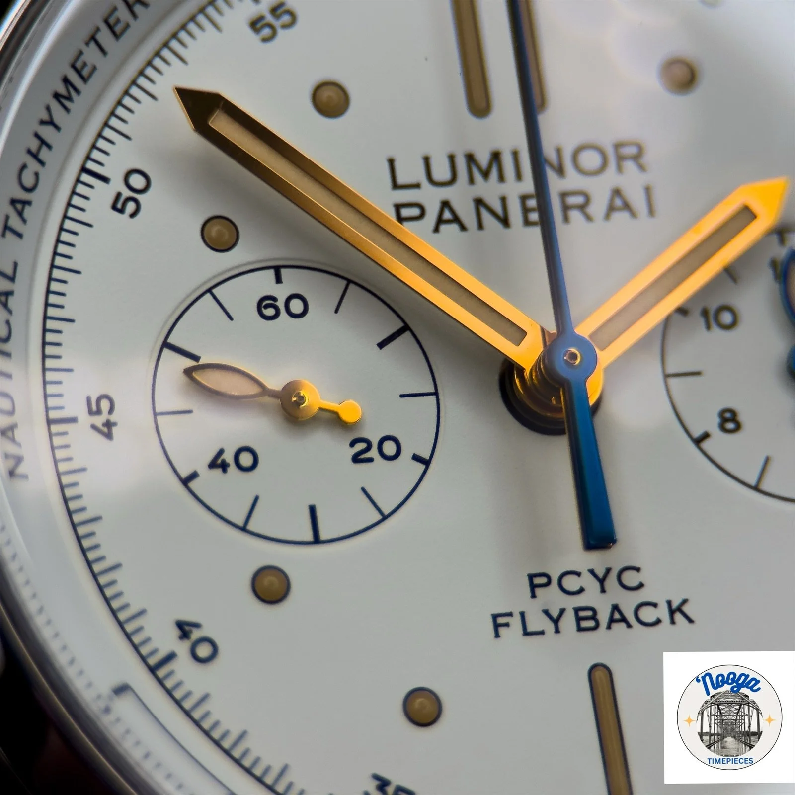 Close-up of a luxury wristwatch showing the brand name 'Luminor Panerai', with orange and blue hands, and various subdials including one labeled 'РУС C Flyback'.