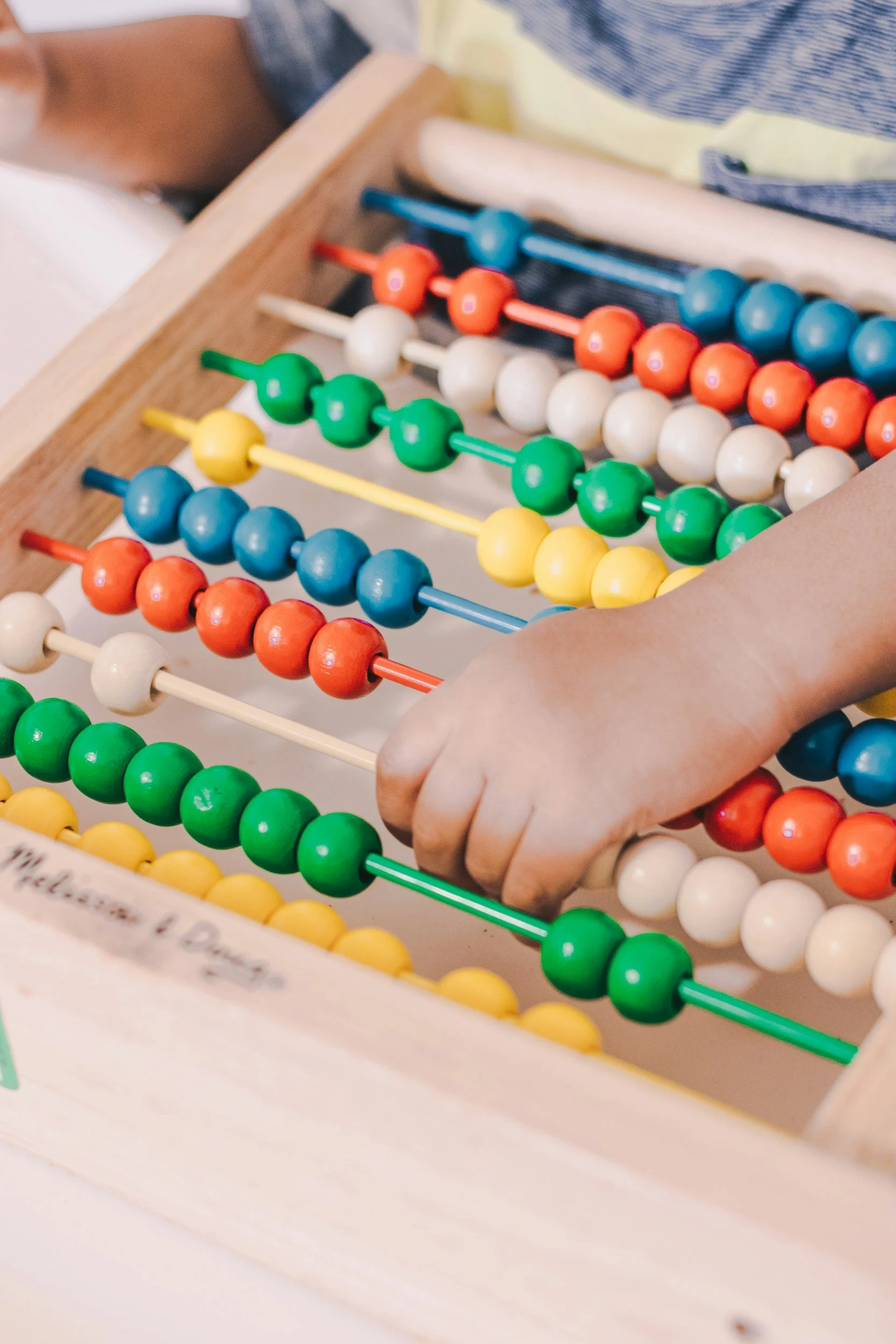 young child using an abacus to practice counting and kindergarten math