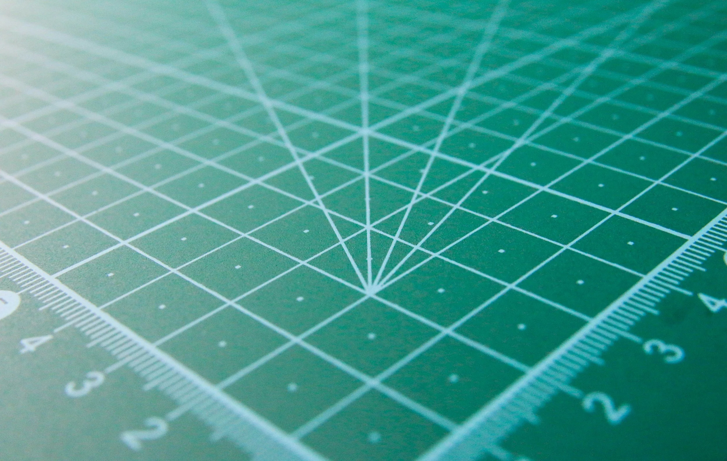 Green grid mat with ruler markings resembling a coordinate plane