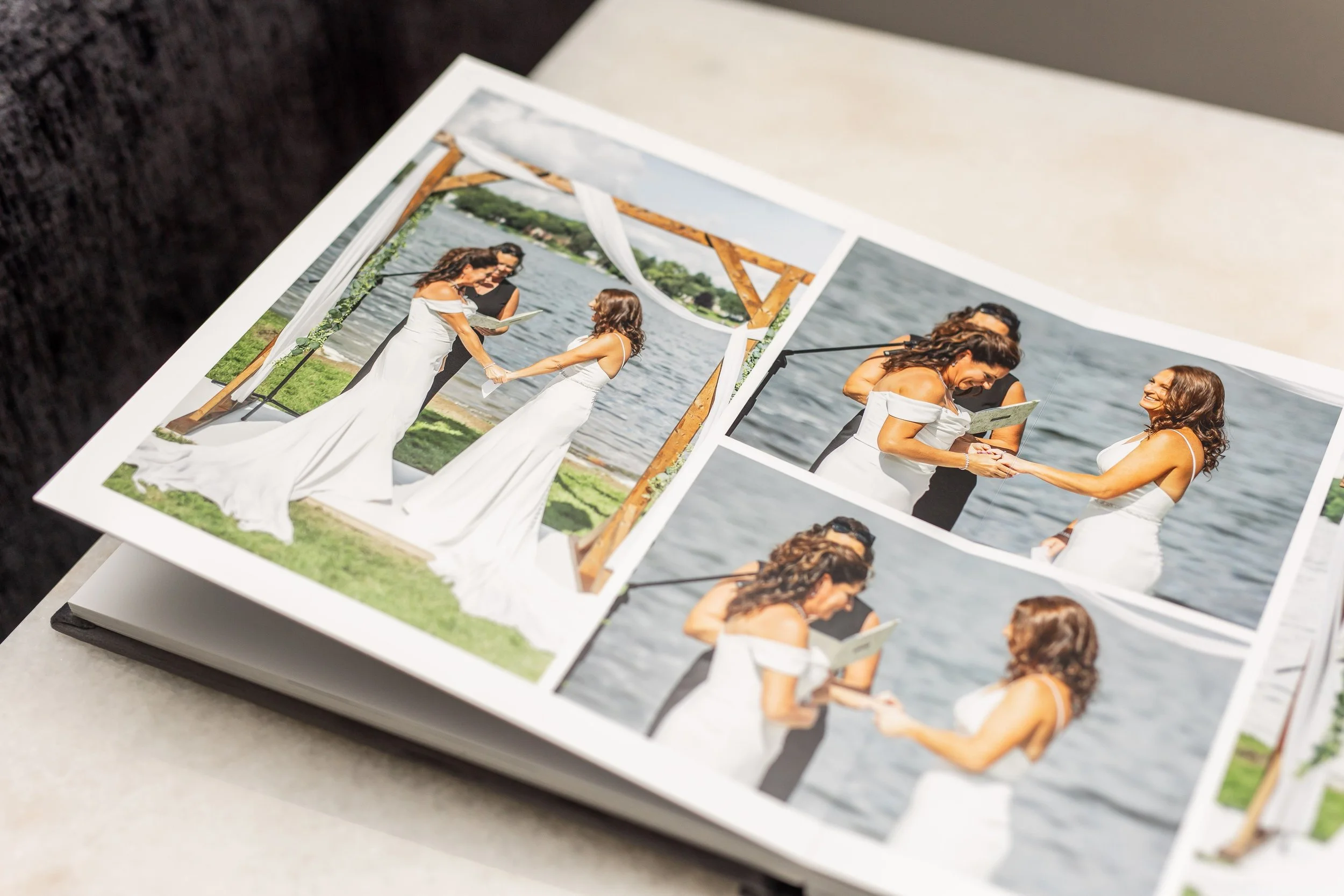 A photo album showing pictures of a wedding ceremony beside a lake, with a woman in a white dress exchanging rings with another woman, both smiling and holding hands.