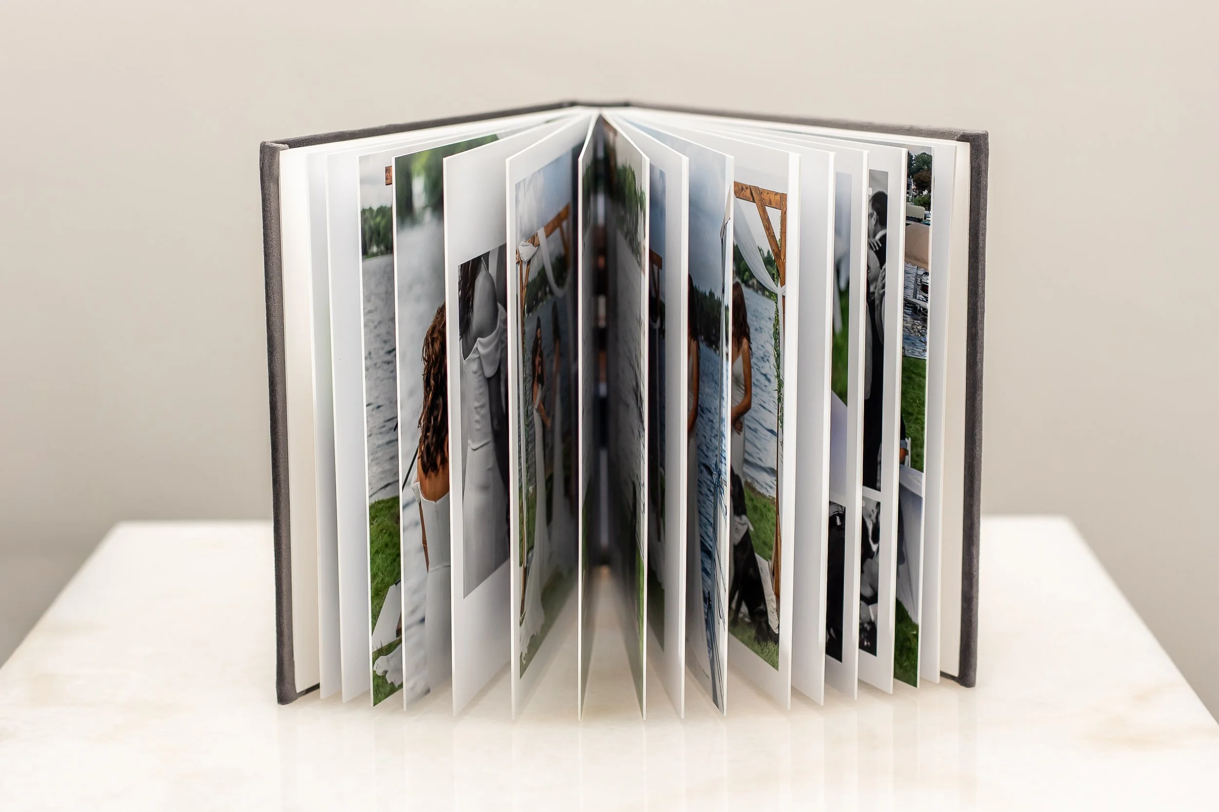 Open photo album displaying several pictures of people outdoors and near water.