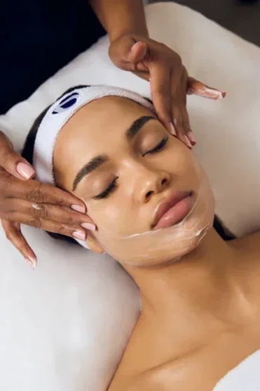 Close-up of a person's face receiving a facial massage.