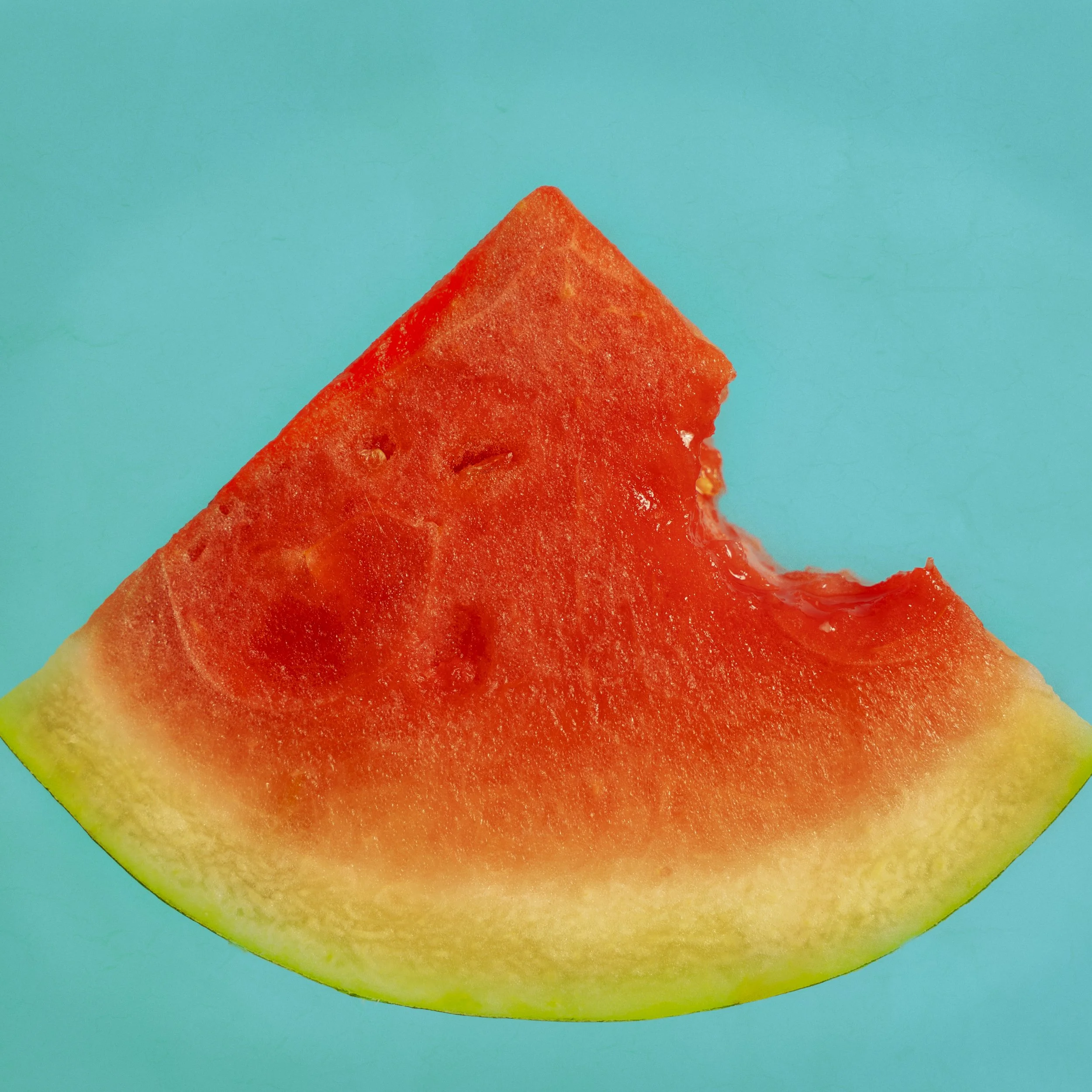 Close-up of a slice of watermelon with a blue background.